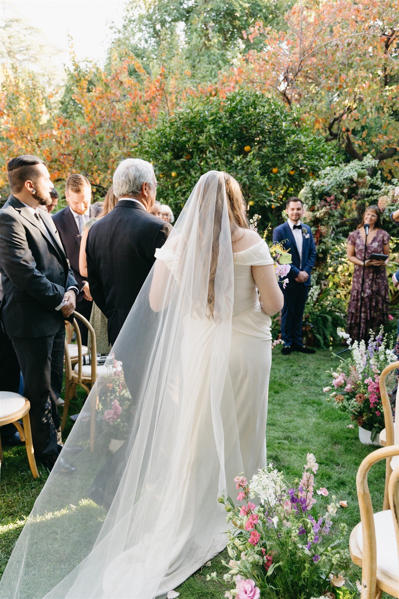 bride walks down the isle during her intimate backyard wedding in LA