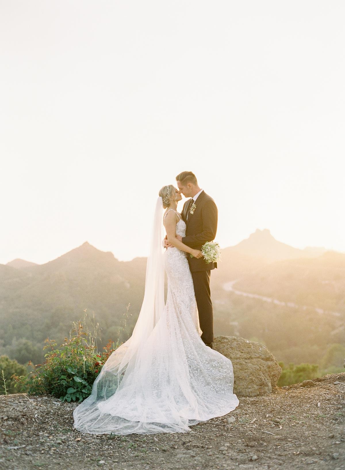 bride and groom at sunset during their gorgeous and romantic wedding on the cliffs of malibu canyon at cielo farms