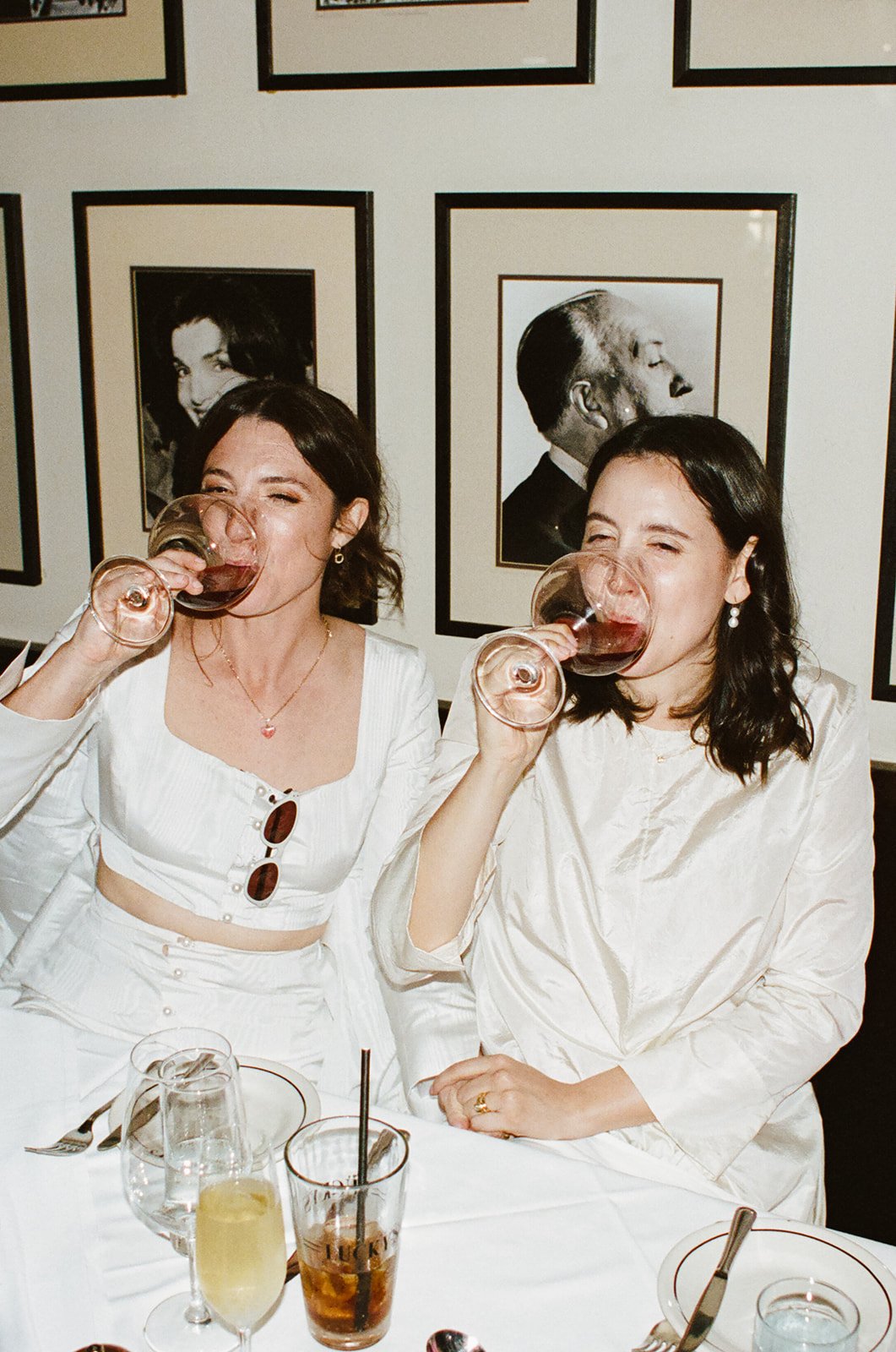 our icon brides taking a sip of wine at their intimate wedding reception