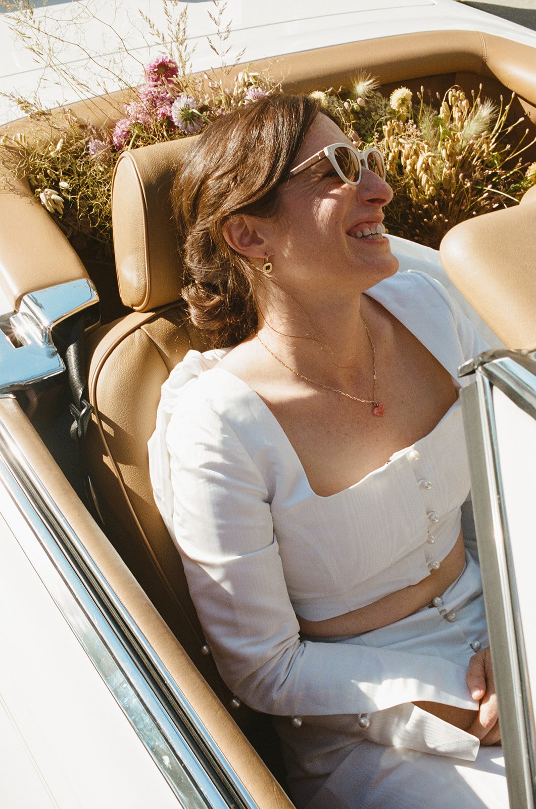 brides' drive off in their vintage convertible after their california wedding