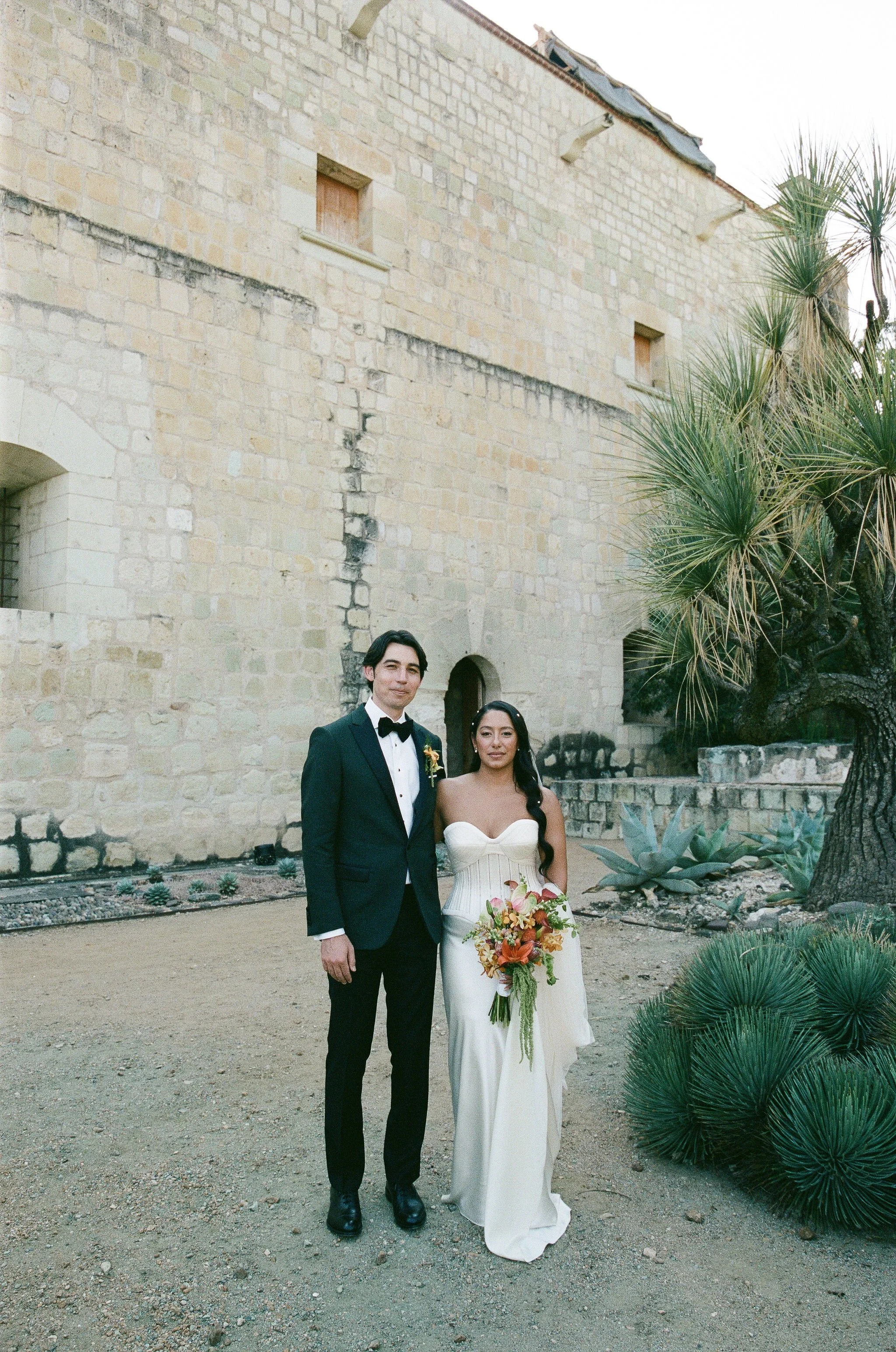bride and groom pose at stunning historic wedding venue in oaxaca mexico