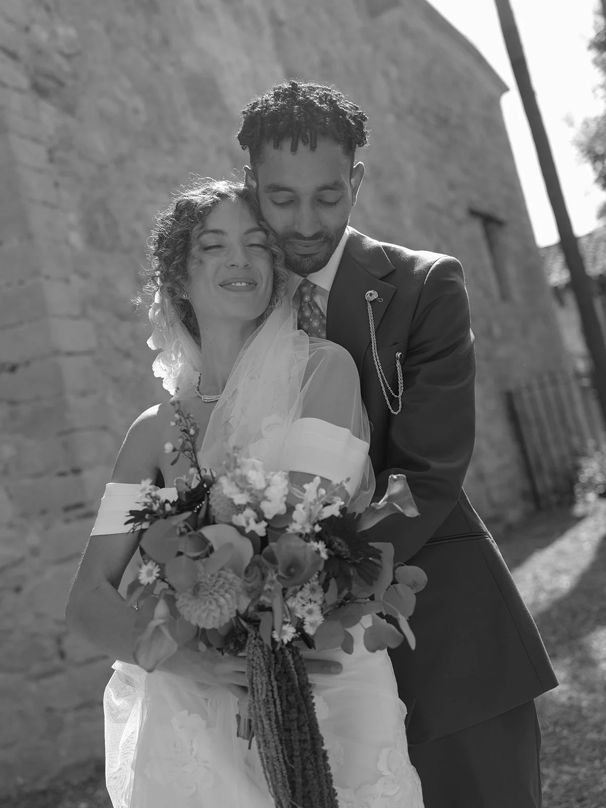 bride and groom embrace during wedding photos at serra plaza in san juan capistrano.