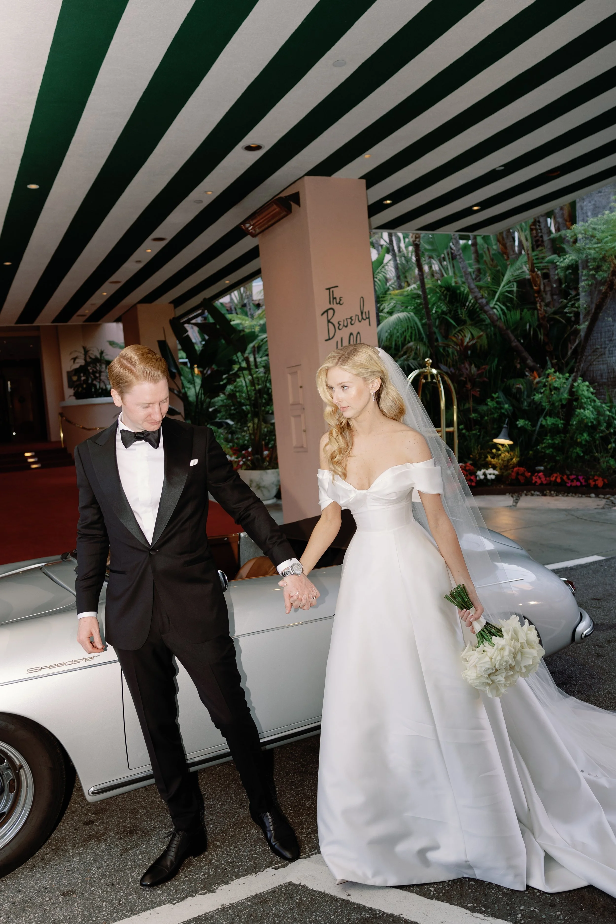 bride and groom with vintage car outside of the beverly hills hotel