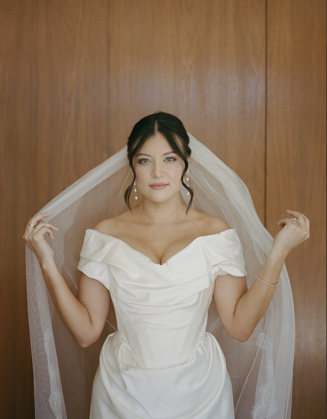 editorial portrait of a bride on her wedding day. her hair is in an updo sleek style. her hair soft and natural.