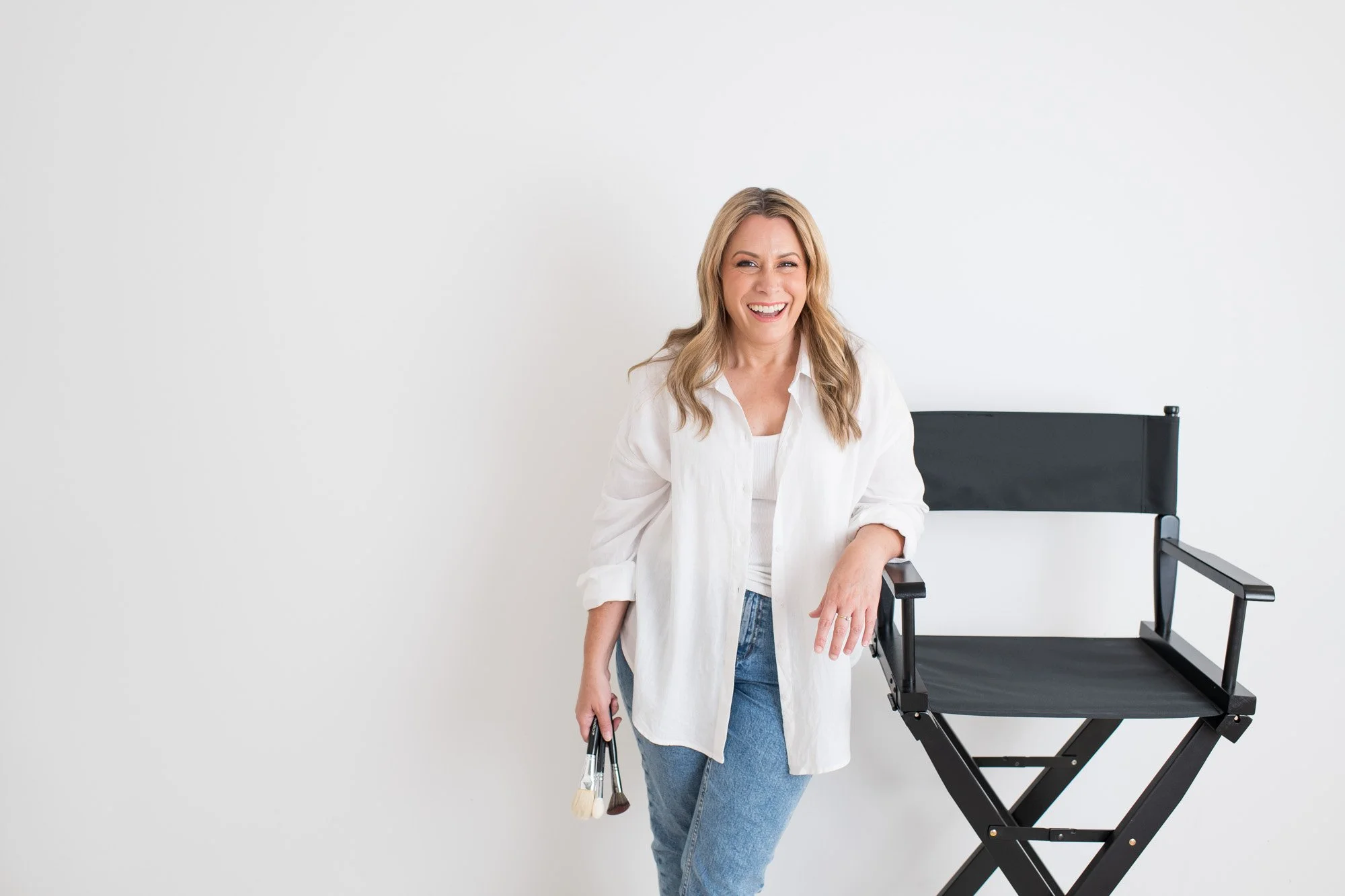 Woman makeup artist standing next to a director's chair at a brand photoshoot in Penrith