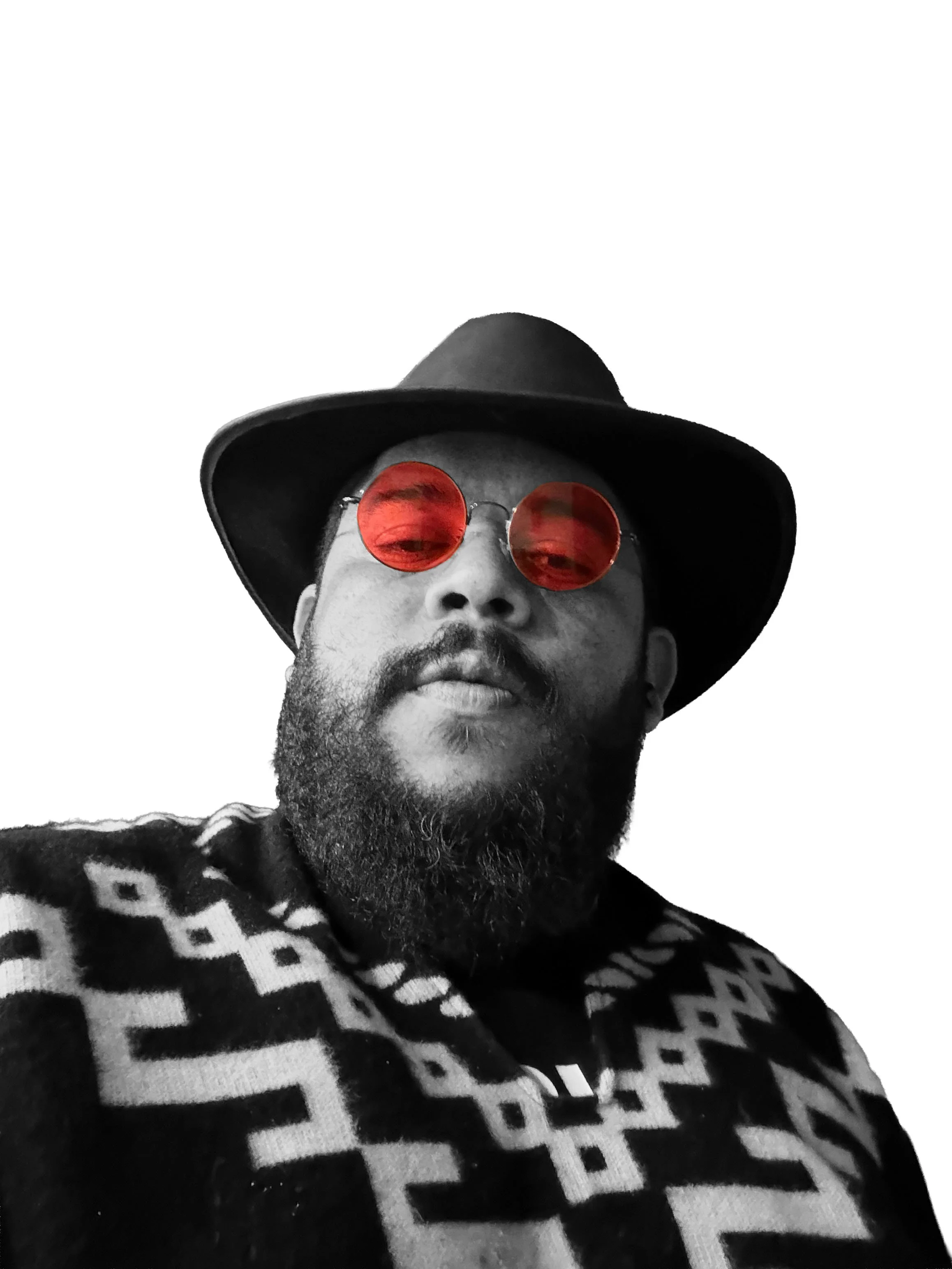 A man with a beard wearing a wide-brimmed black hat and round red sunglasses, dressed in a patterned black and white sweater, against a plain white background.