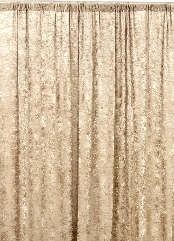 Close-up of beige velvet curtains with vertical pleats.