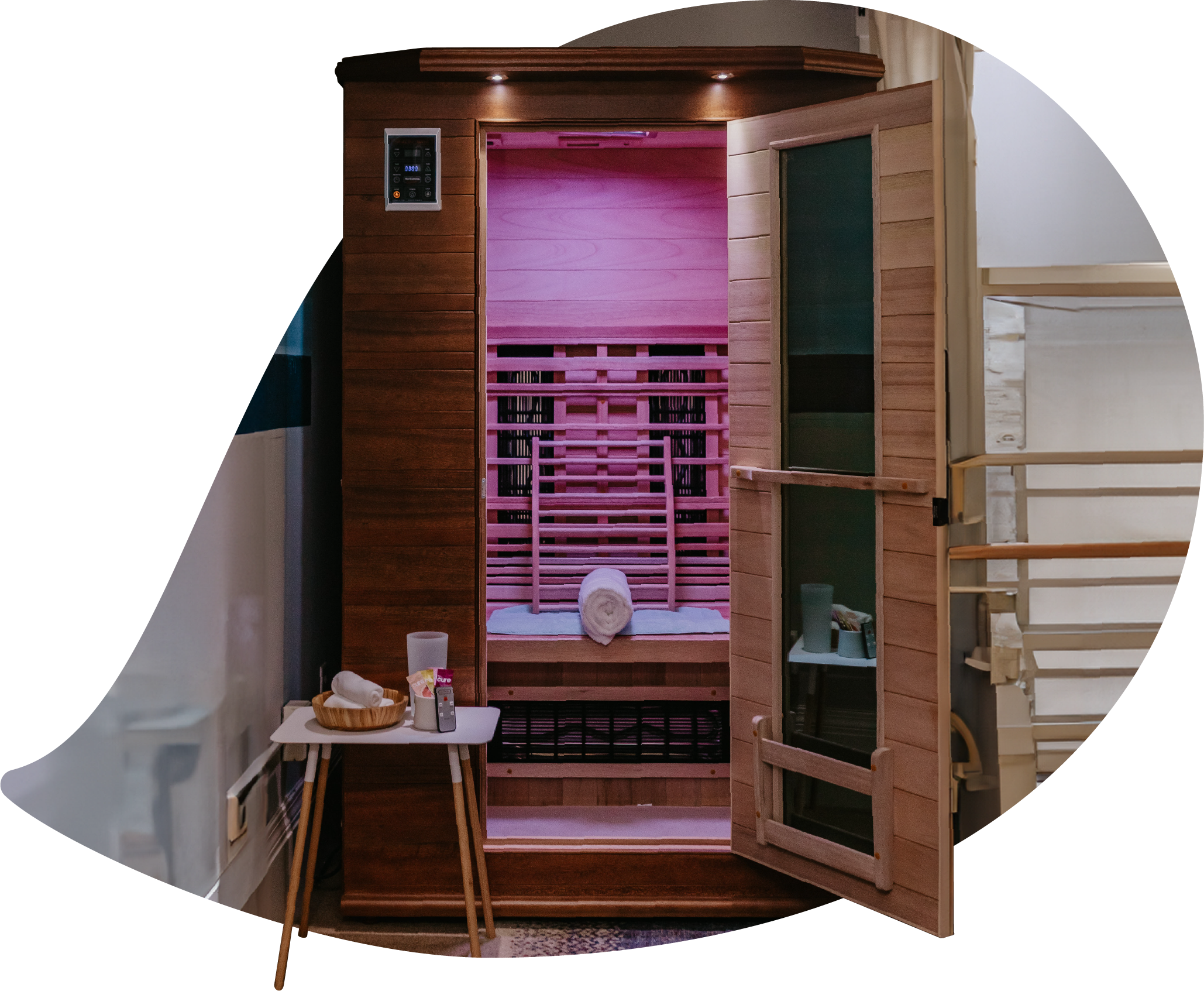 An open infrared sauna with a towel and amenities arranged inside, ready for a heat therapy session.
