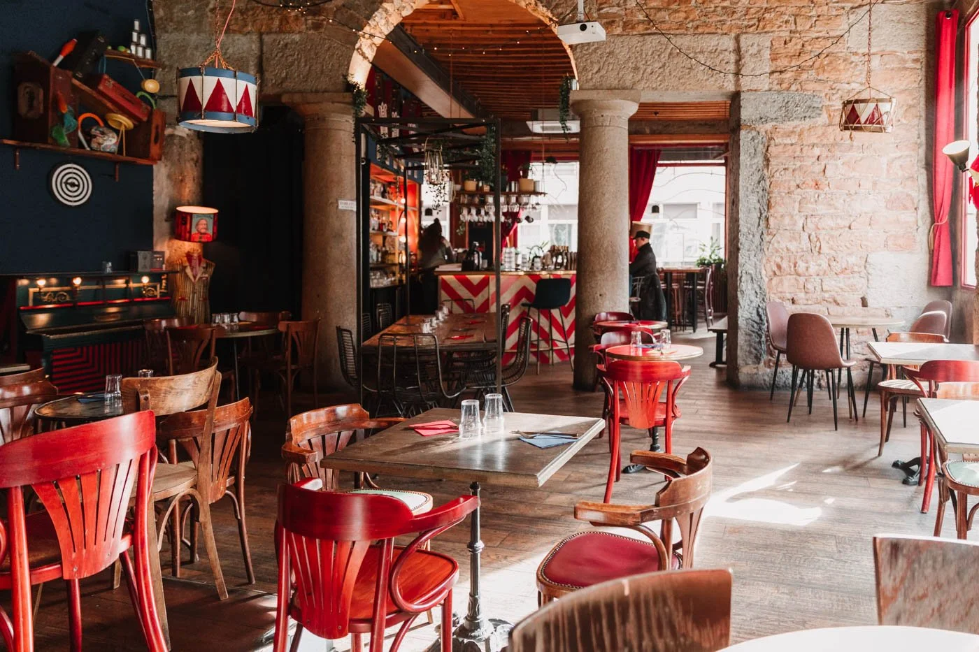 salle du restaurant le milord circus à lyon 9 gare de vaise, avec du mobilier en bois, une décoration rouge et bleu roi, avec des objets hétéroclites du monde du cirque