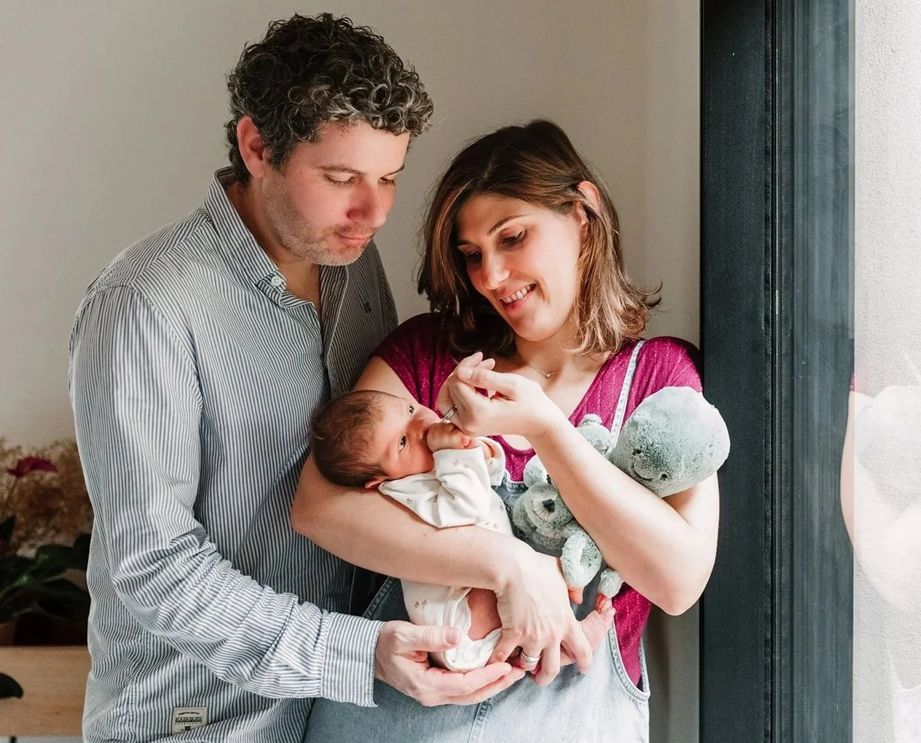 Couple de parents regardant leur bebe dans les bras de maman