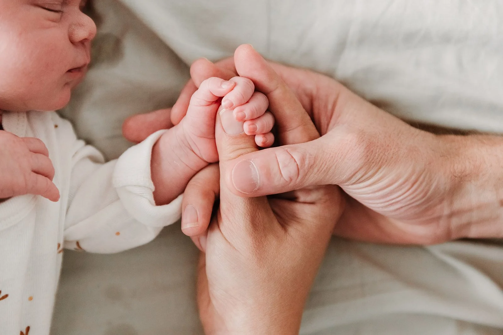 Main de bebe dans les mains de ses deux parents