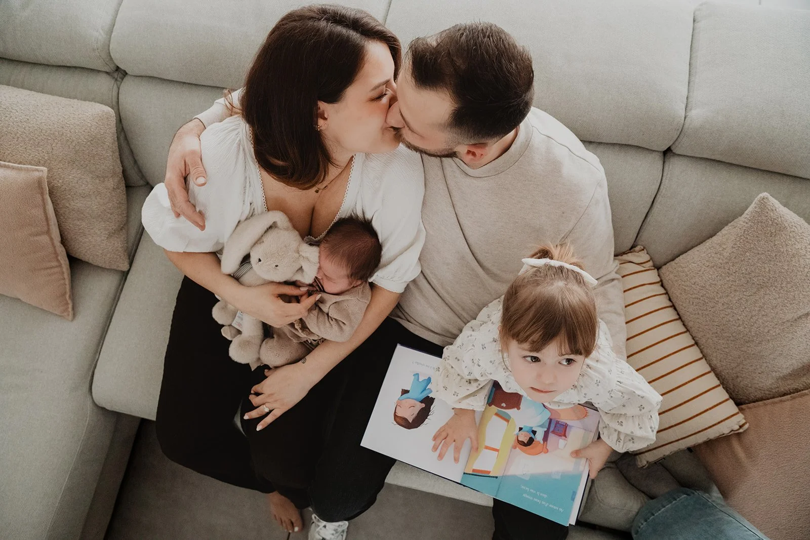 Couple vu d'en haut s'embrassant avec leurs petits enfants sur les genoux dans canape