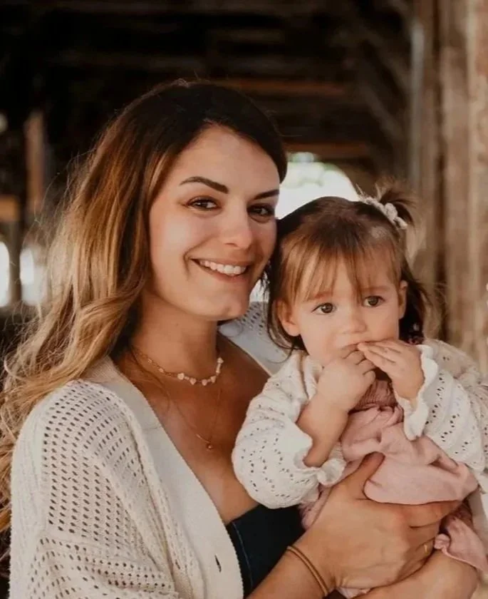 Femme souriant tenant sa petite fille dans ses bras tons neutres