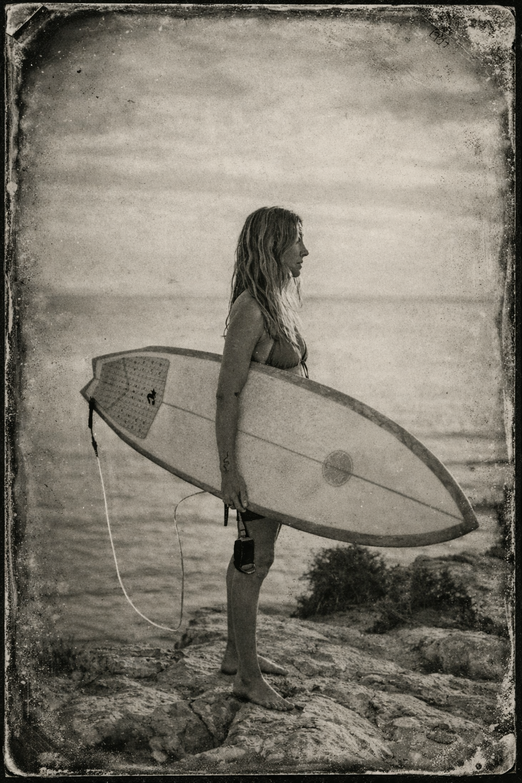 Contemplative surfer on rocky shoreline.png