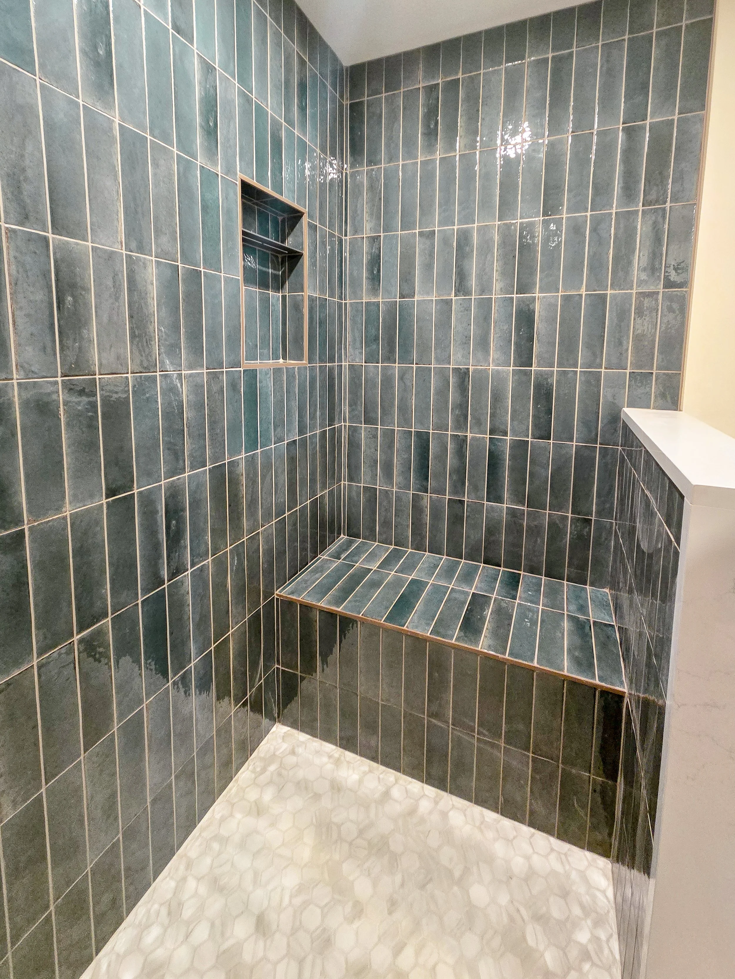 Walk-in shower with gold fixtures.