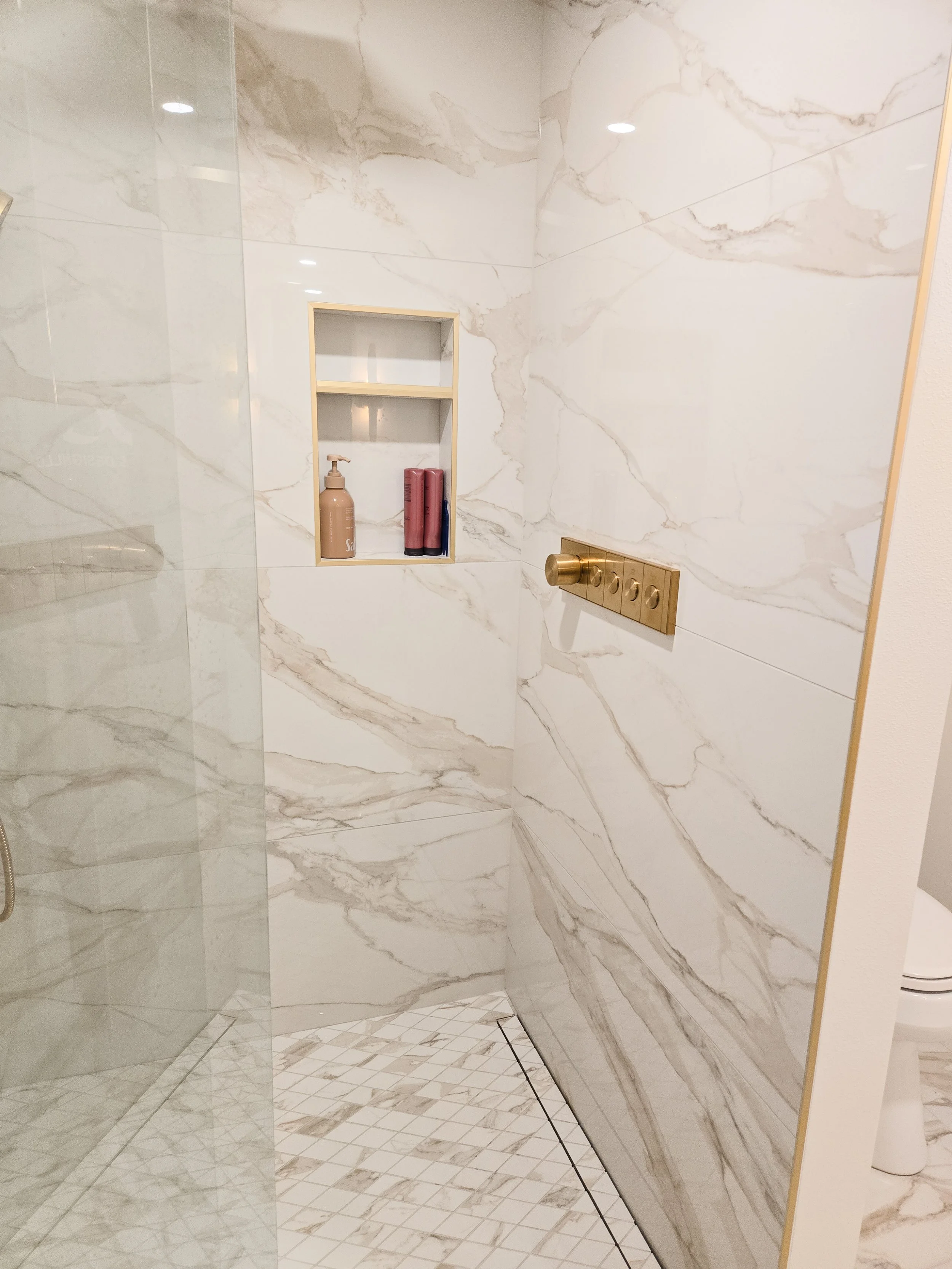 Custom Luxury Shower with a custom-tiled oasis featuring large-format tiles, a sleek linear drain, and built-in storage niches in Wisconsin Dells.