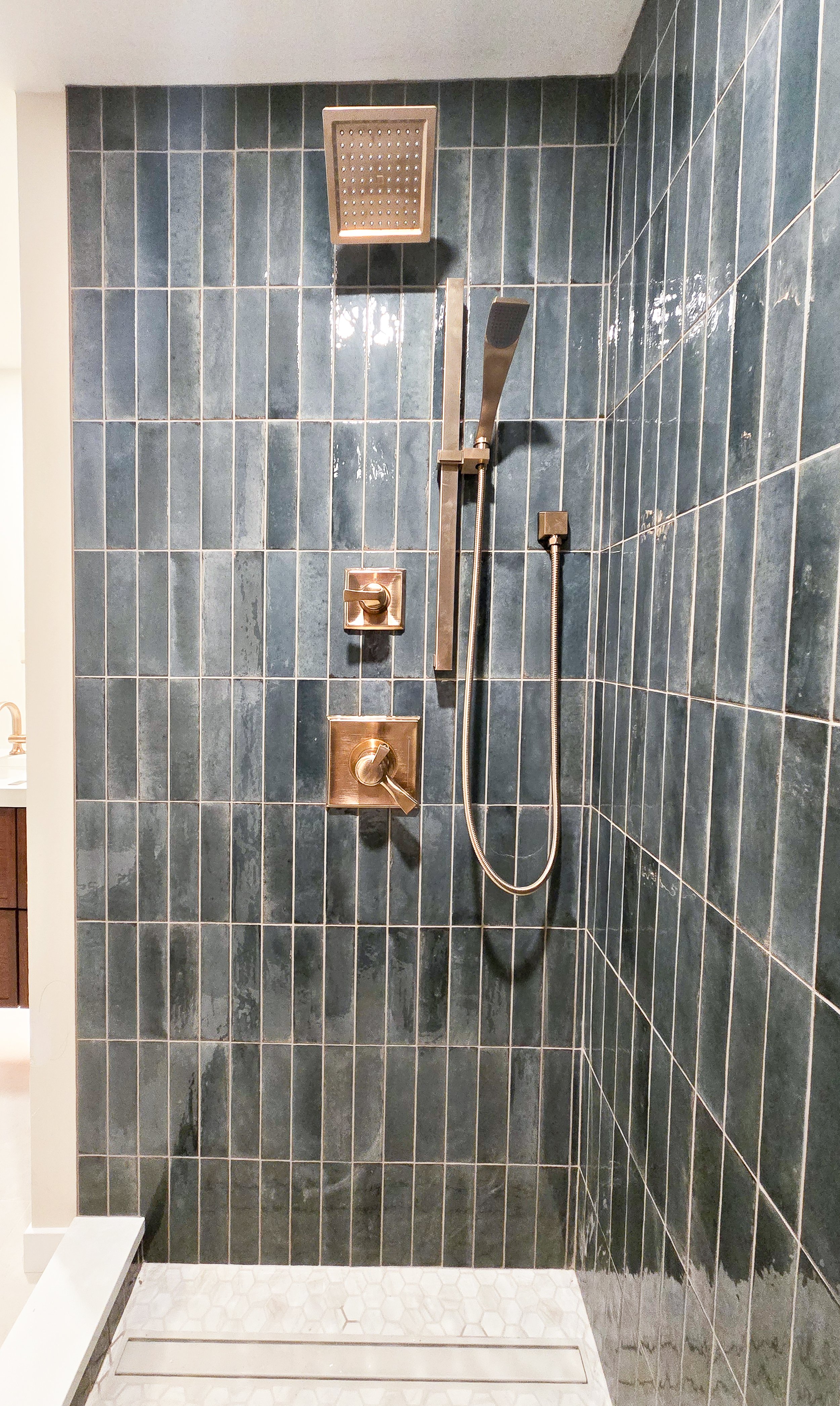 Walk-in shower with gold fixtures.
