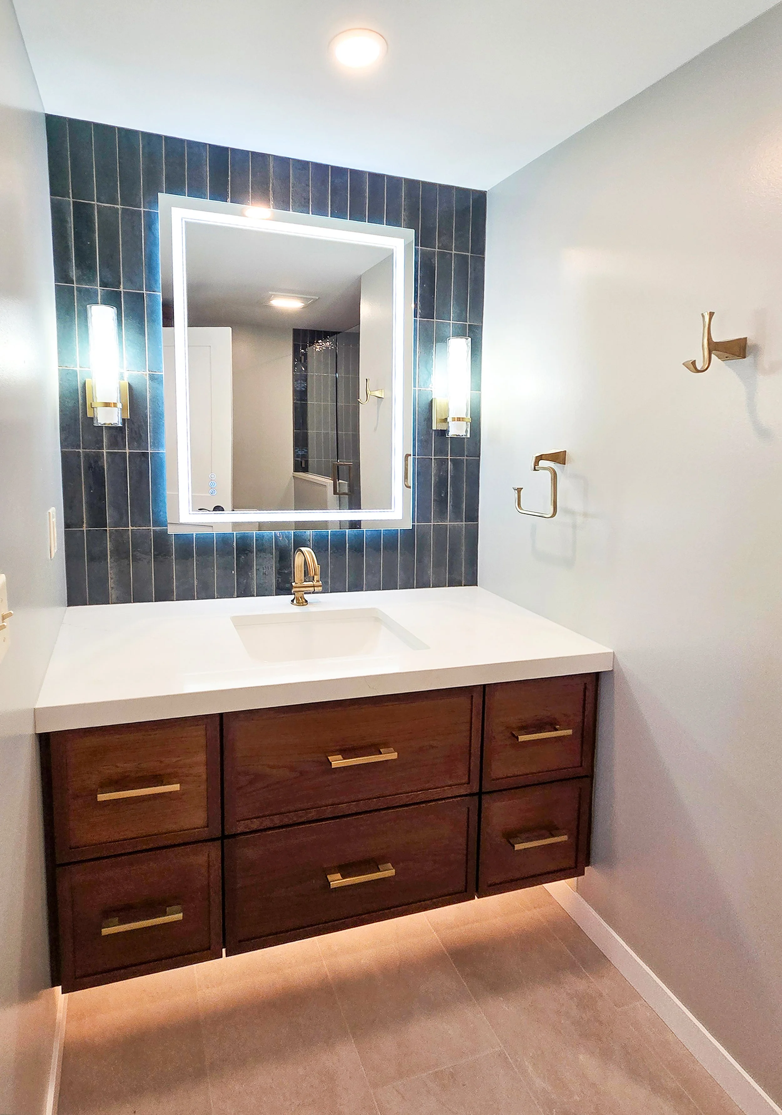 Modern bathroom with hand-painted tile backsplash and floating vanity.