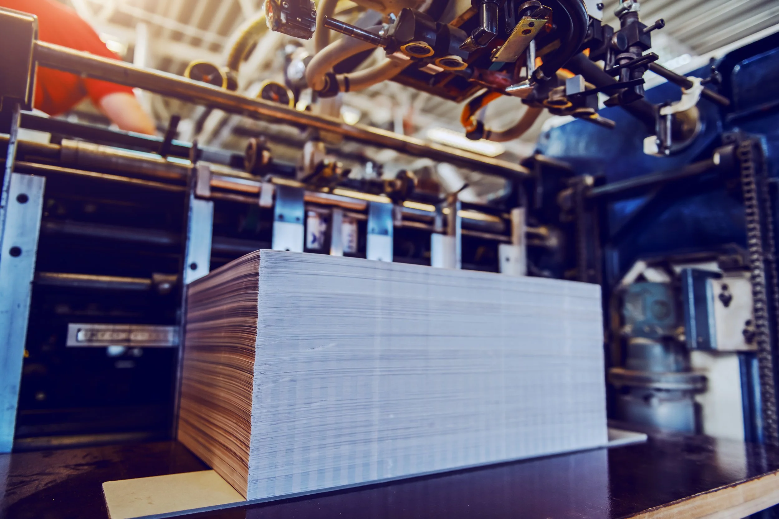 Print media is a great addition to any digital marketing campaign and can make a huge difference in the success or failure of your sales. This image depicts a stack of printed sheets being cut after passing through a large format printer.