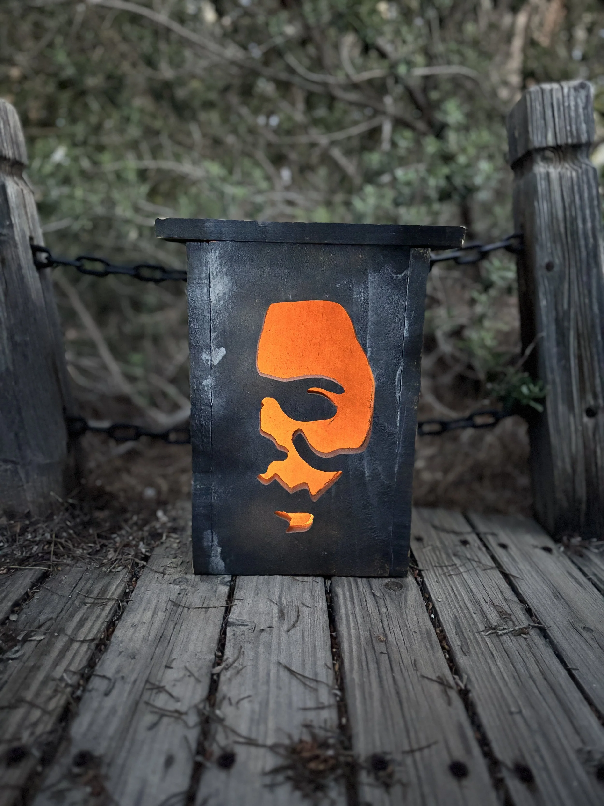 Customized cedar wood Halloween lantern named Mikey Sr, handmade rustic outdoor holiday decor with atmospheric orange glow.