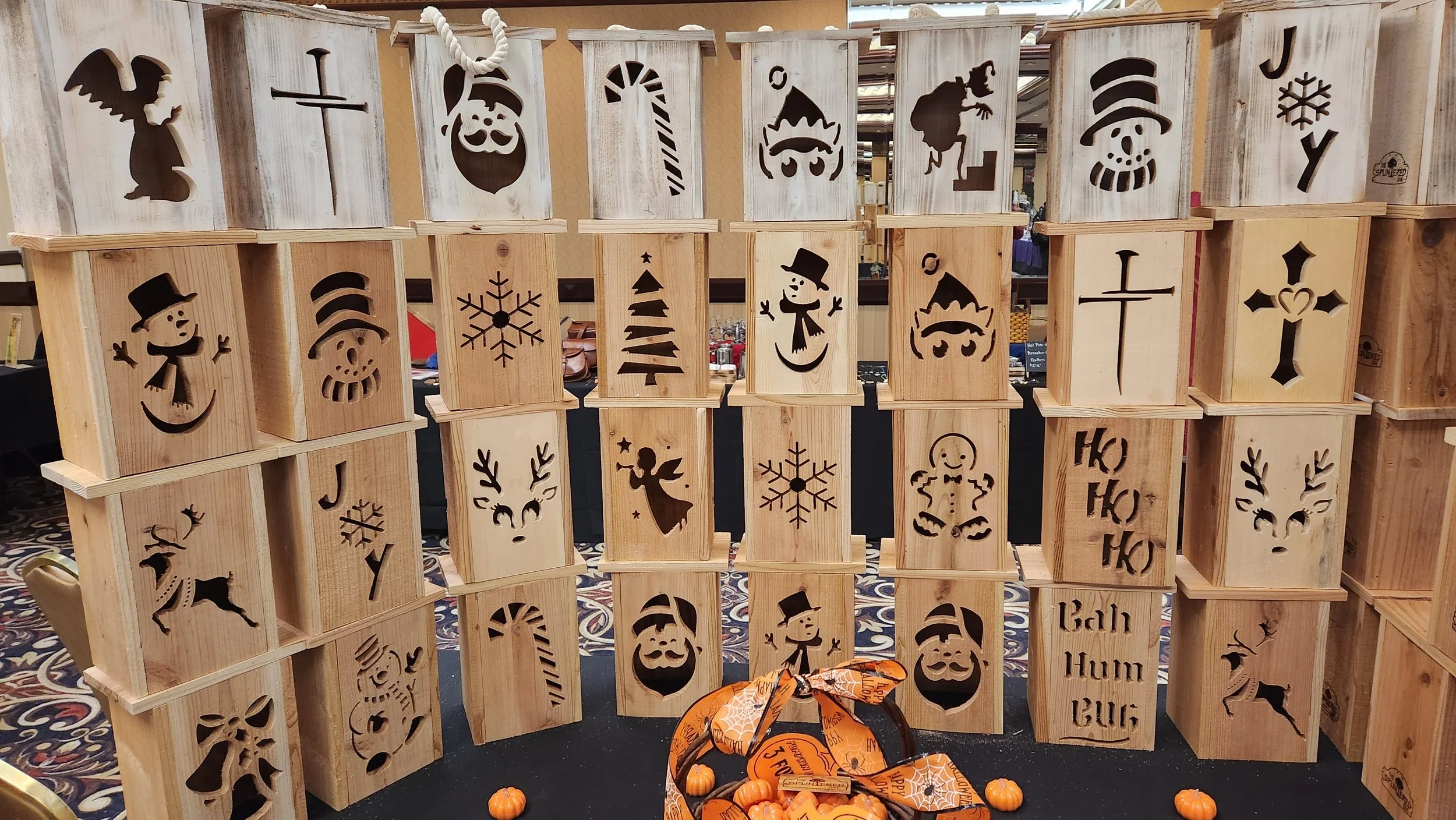 Collection of handcrafted rustic cedar Christmas lanterns with snowman, reindeer, and holiday designs.