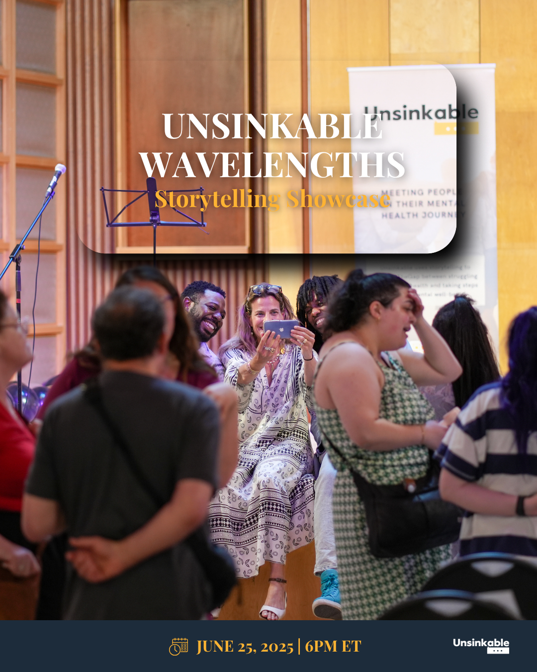 A diverse group of people at a storytelling event, with a woman in the center taking a photo on her phone, smiling and laughing.