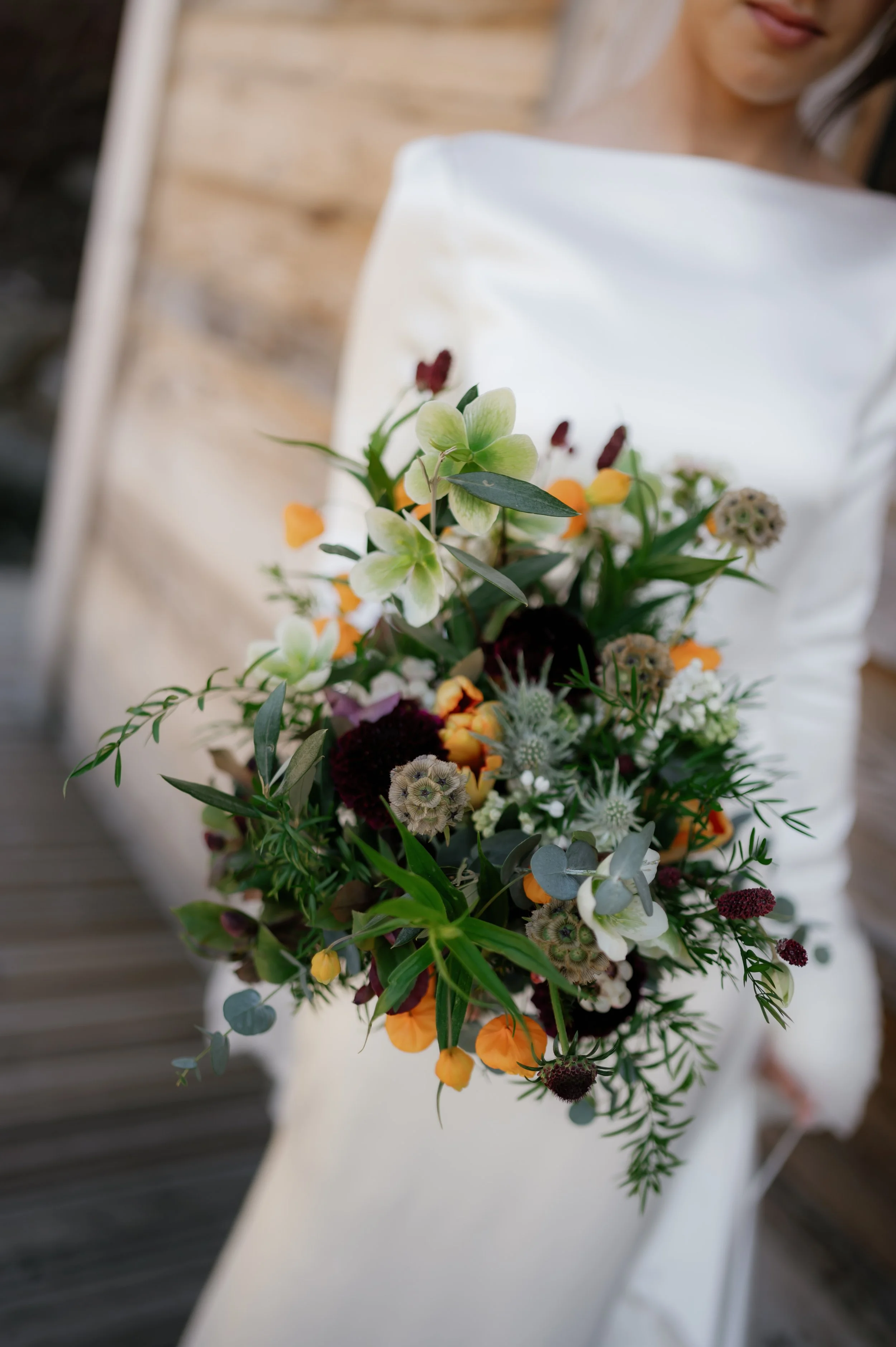 Dainty rustic bridal bouquet with organic style, featuring hellebores and wild alpine florals for a natural wedding vibe.