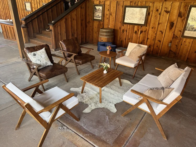 A curated Stargazer lounge of armchairs, side tables and fresh florals set up at Red Cliffs Lodge