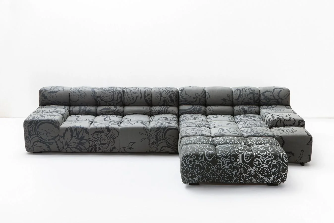 B&B Italia sofa (Tufty Time by Patricia Urquiola), grey sofa upholstered in a floral-patterned textile, placed against a white wall, showcasing contemporary surface pattern design applied to modern furniture. 