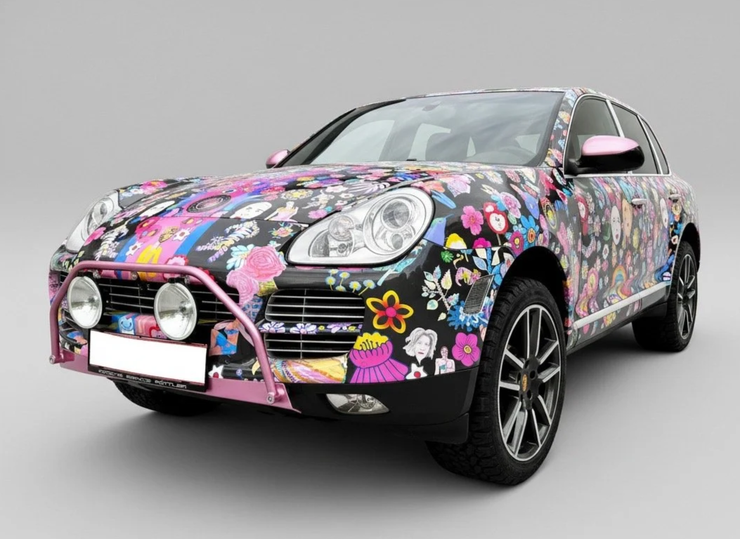 Vehicle surface intervention using hand-drawn ornamental pattern applied across automotive body panels.