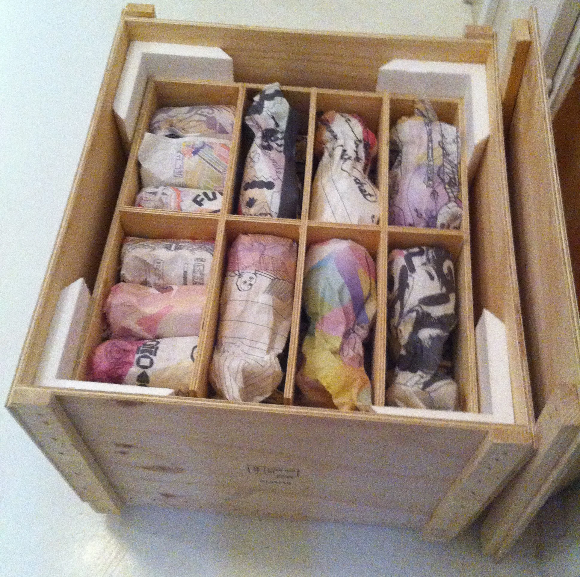 Ein Holzschrank mit mehreren Fächern, in denen zerknüllte Geldscheine aufbewahrt werden.