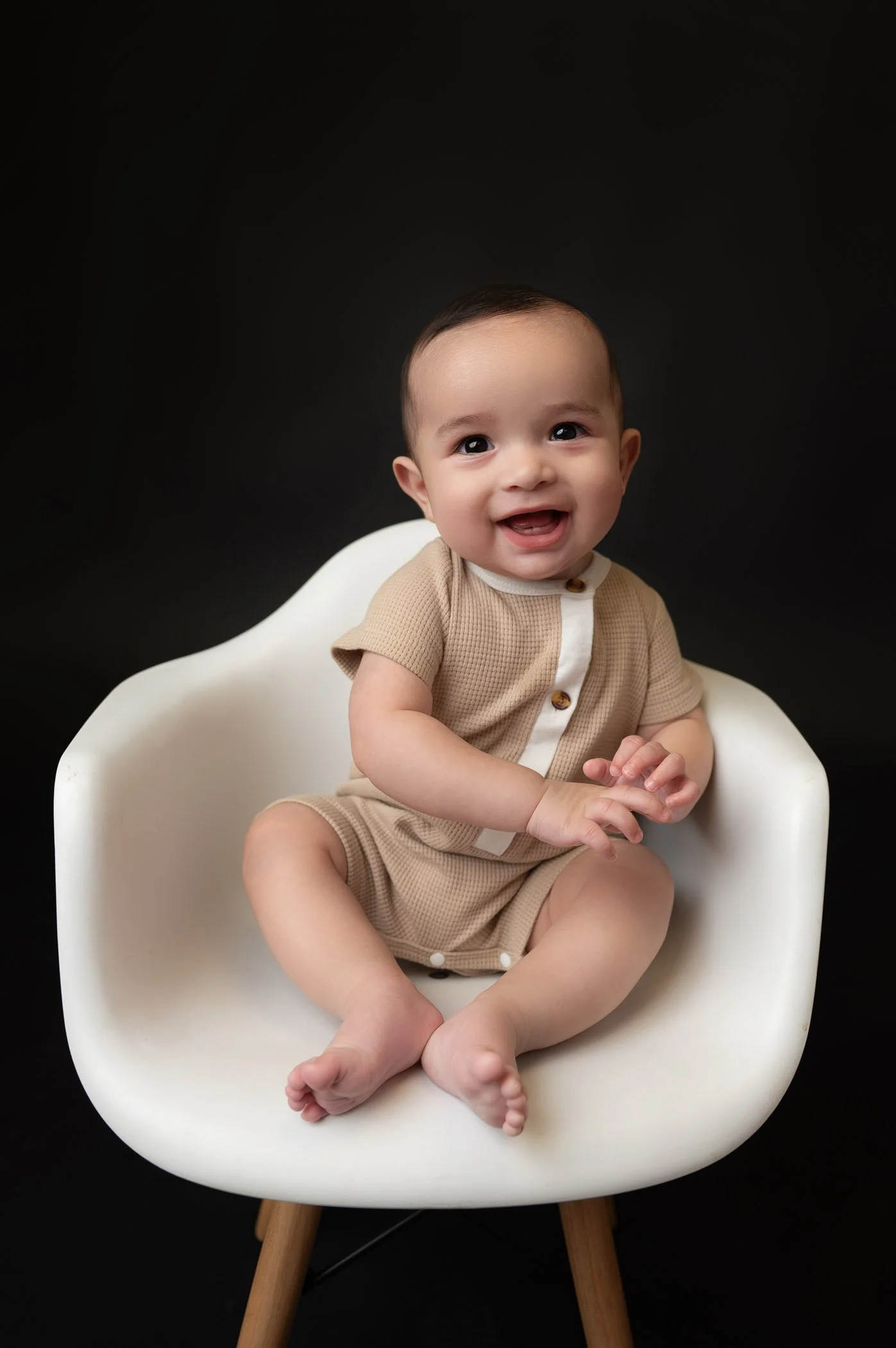 baby boy during first birthday cake smash session in houston studio on black background