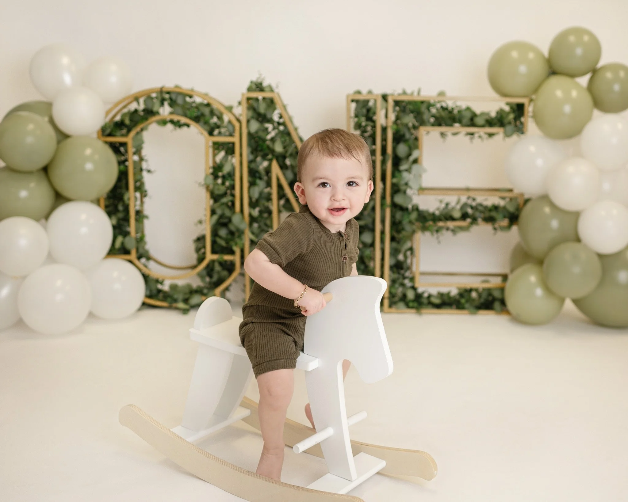 ONE letters with greenery and balloons