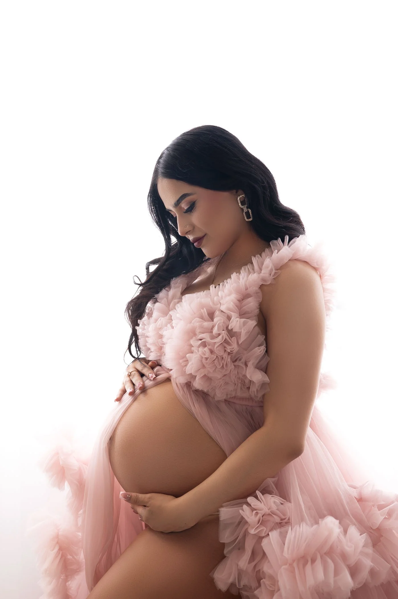 maternity session with pink fluffy dress on white background in houston studio