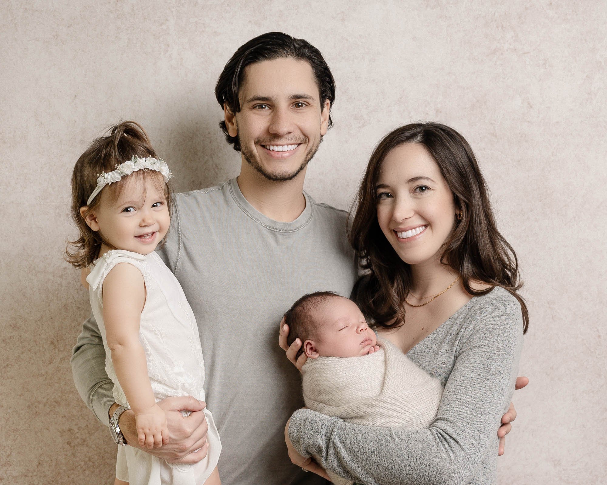 family portrait during newborn session on neutral background wearing grey