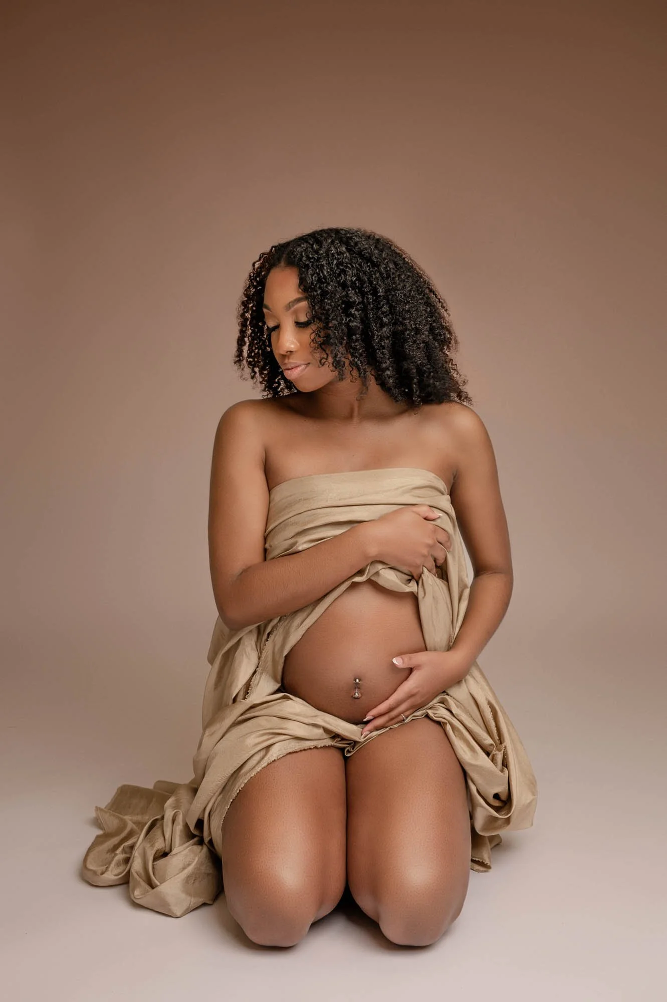 houston maternity session with brown background and golden draped fabric
