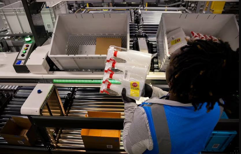  A worker picks an order inside of Walmart’s 1.5-million-square foot online fulfillment center in Lancaster. The platform can be adjusted for comfort to her height. (Juan Figueroa) 