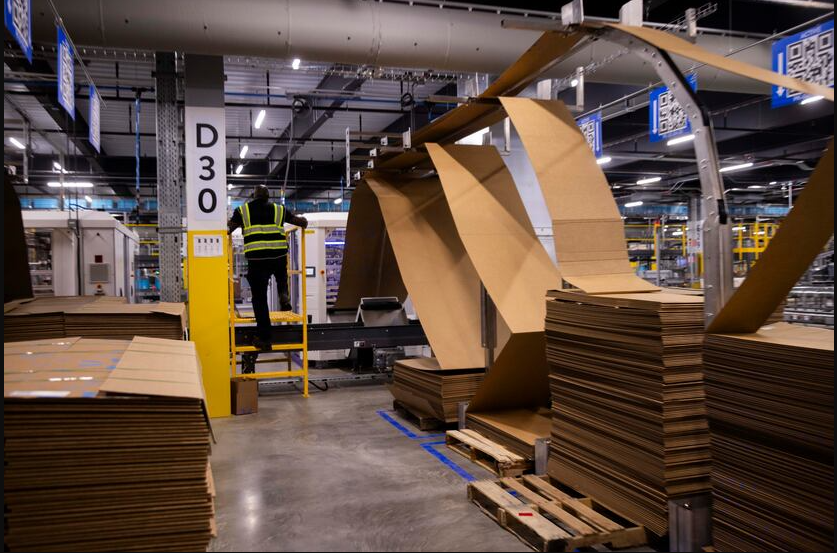  Stacks of cardboard sit behind the box making machine inside of Walmart’s 1.5-million-square-foot online fulfillment center in Lancaster. (Juan Figueroa) 
