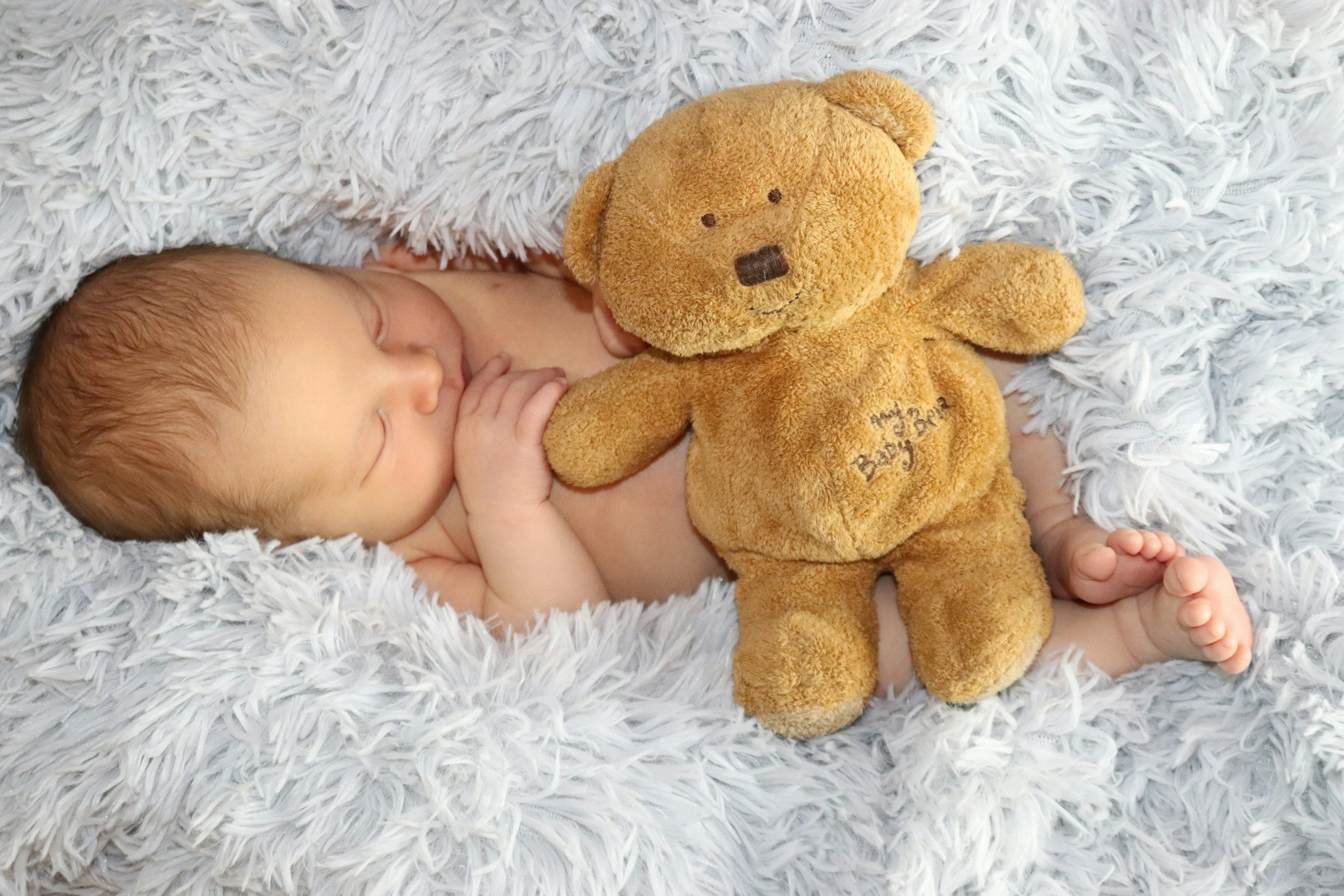Baby holding a teddy bear, perfect for gifting or special occasions on the Gold Coast