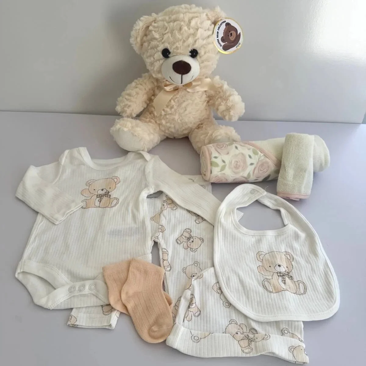 A beautiful baby gift with a soft teddy cream colour to cordinate with the 5 pieces of clothing included. Also inlcudes a hooded towel and washer set.