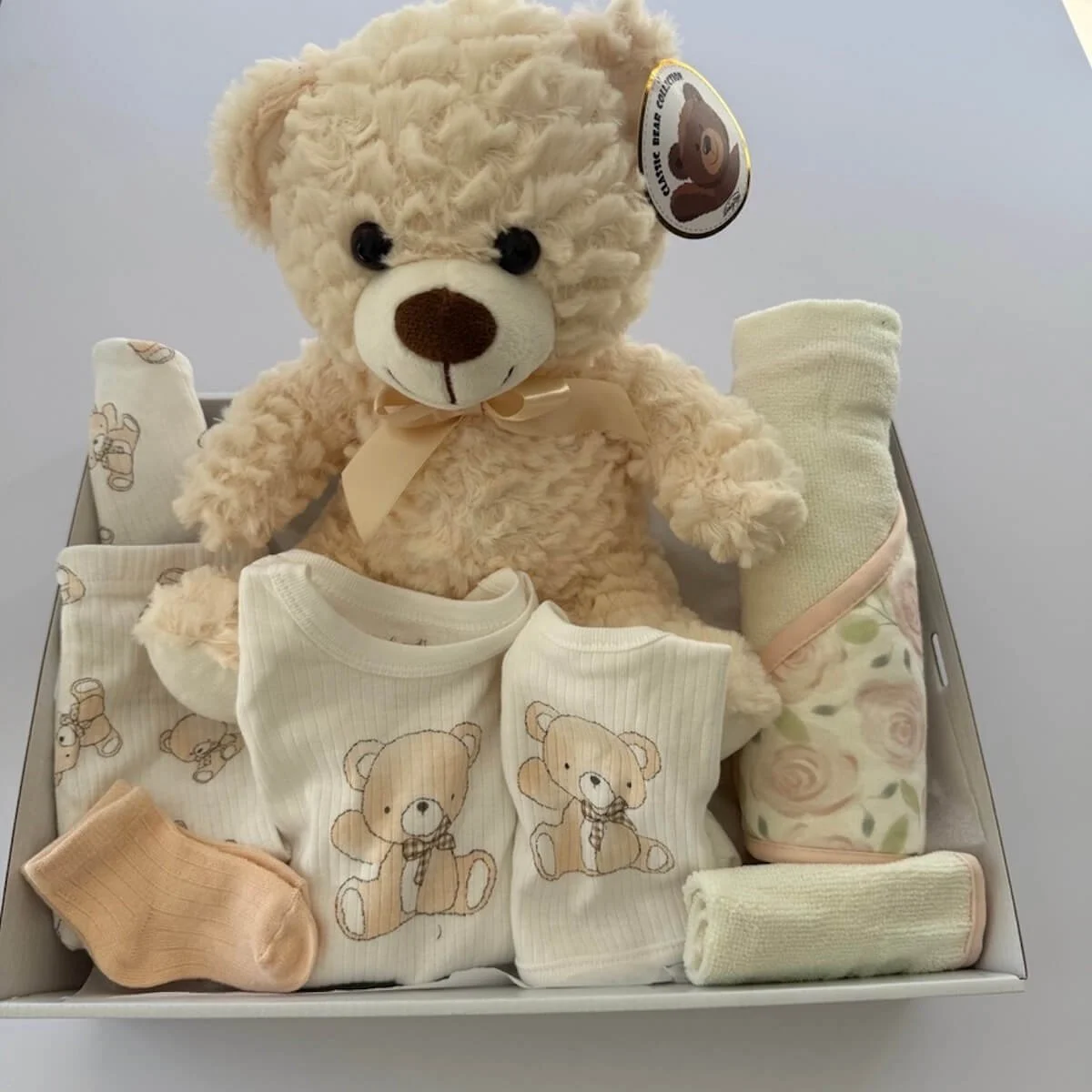 Baby gift hamper for delivery on the gold coast with a soft teddy and a hooded towel and washer and clothing.