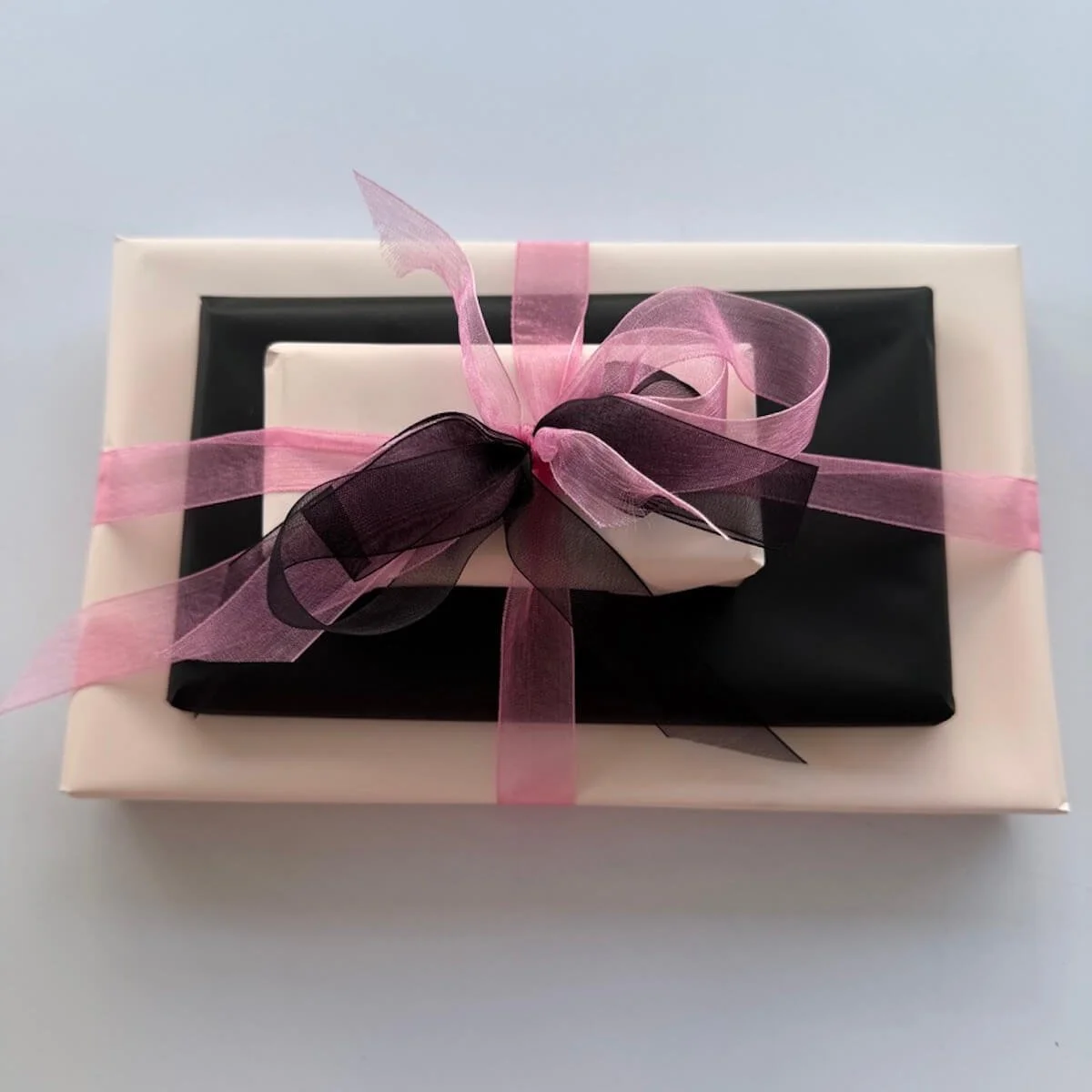 Chocolate tower with wrapped items with ribbons and bows. Made up with Lindt collection 184g, whittakers 200 block of chocolate and gourmet fudge 100g.