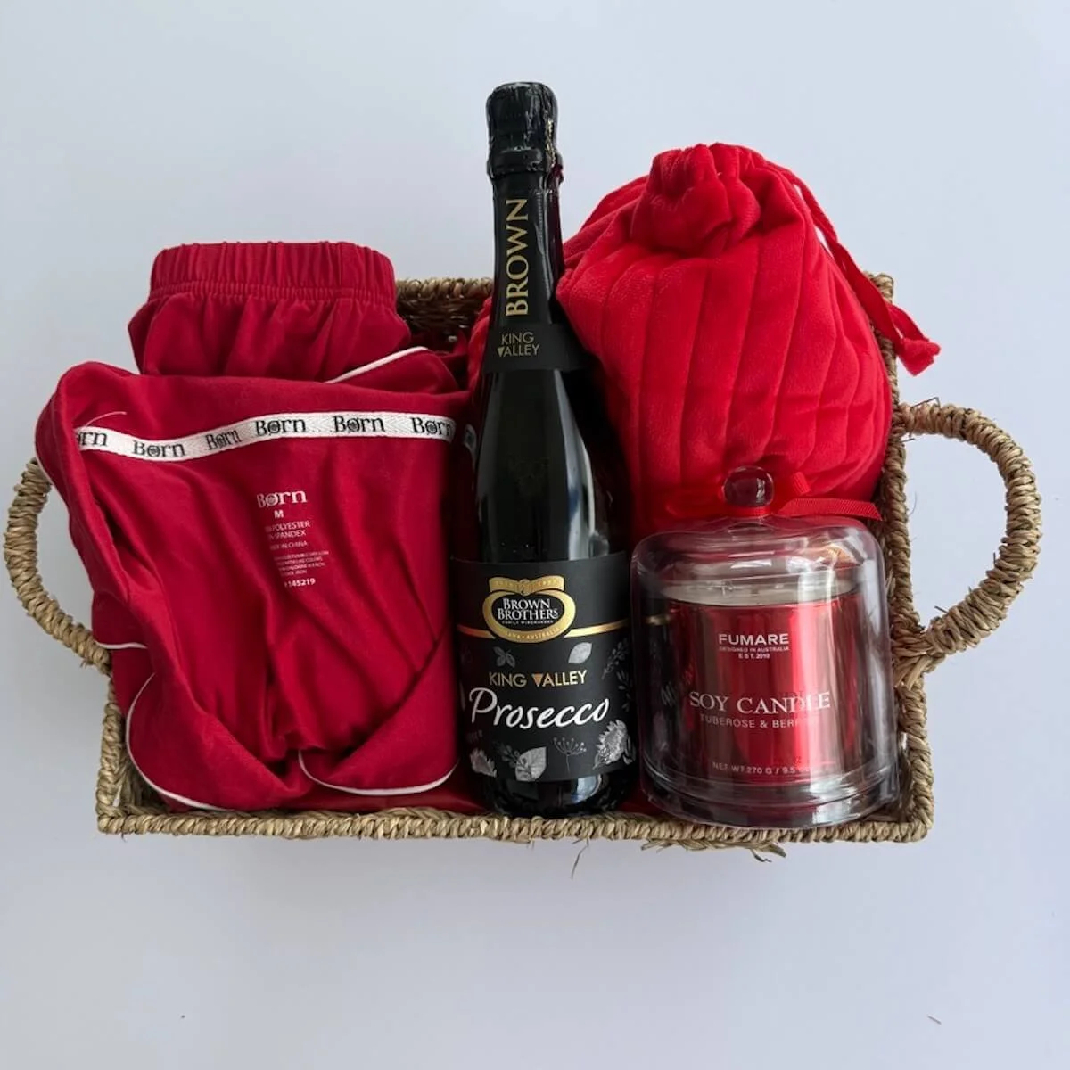 Luxury Bed and Bubbles gift hamper with short pyjamas, Prosecco bottle, scented candle, and assorted pamper products.