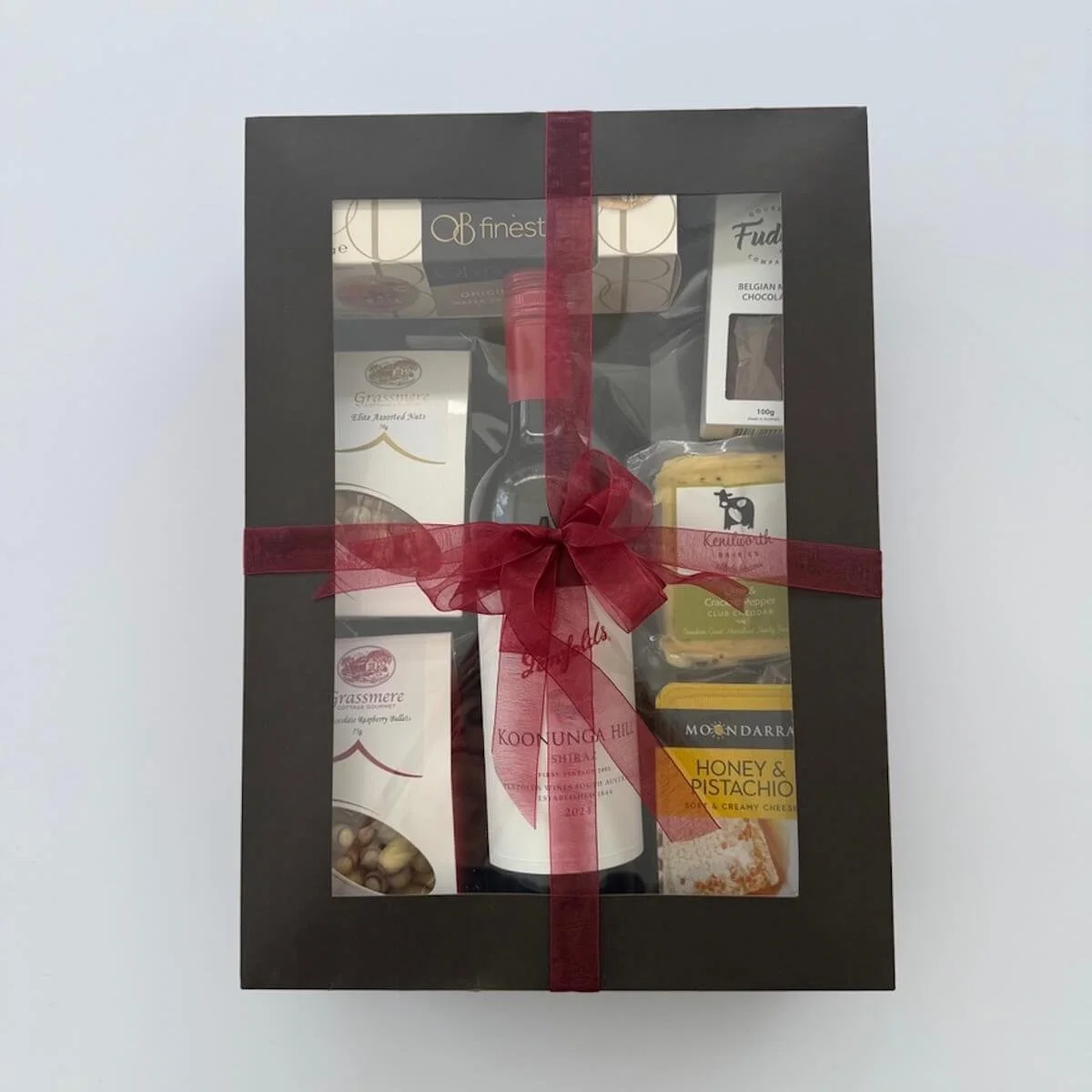 The Maudsland wine and cheese hamper with a window lid includes a bottle of wine, 2 cheeses, crackers, Fudge and gourmet treats.