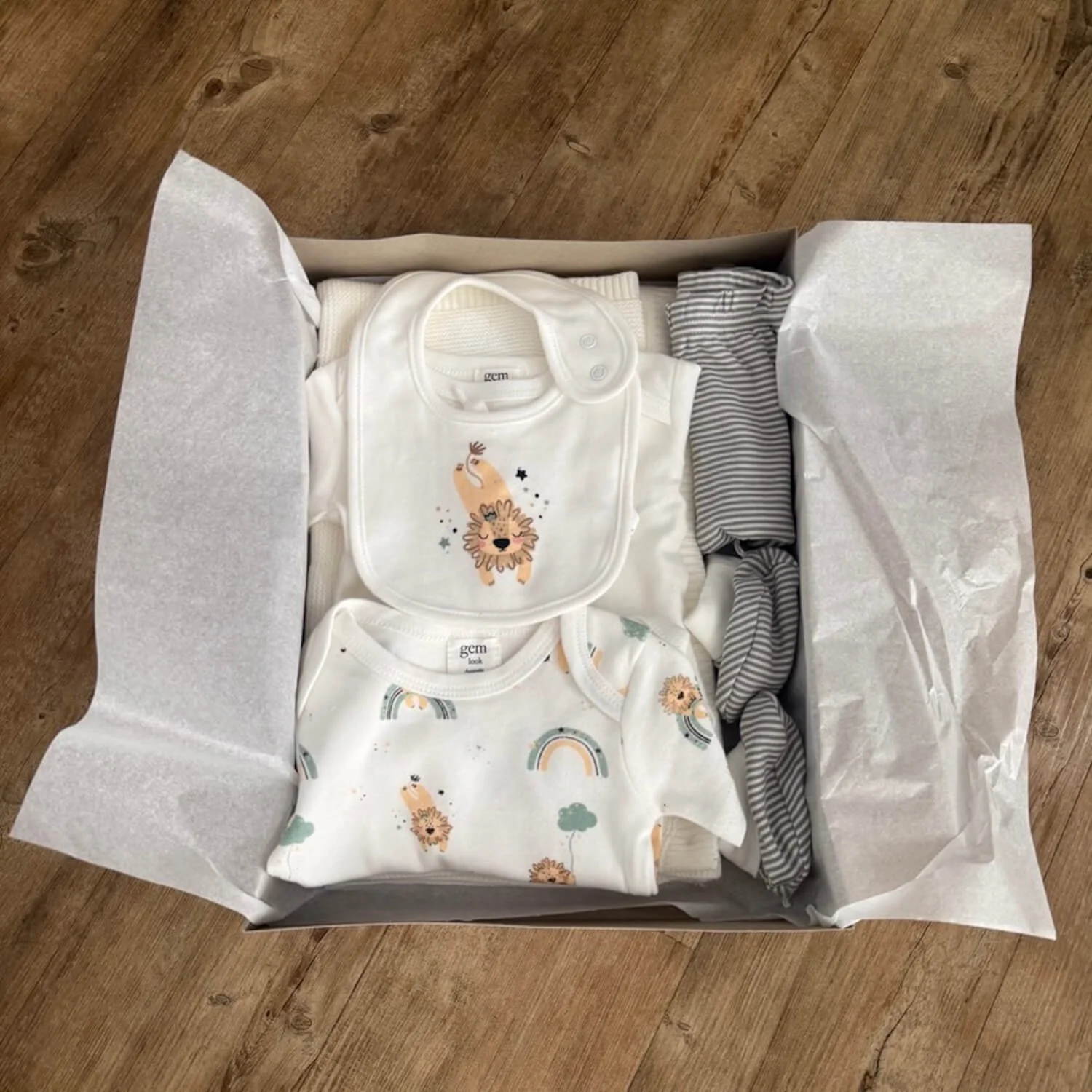 Open Love You to the Moon & Back Baby Gift Box showing knitted blanket, matching baby clothing set, and pram rattle toy neatly packed inside