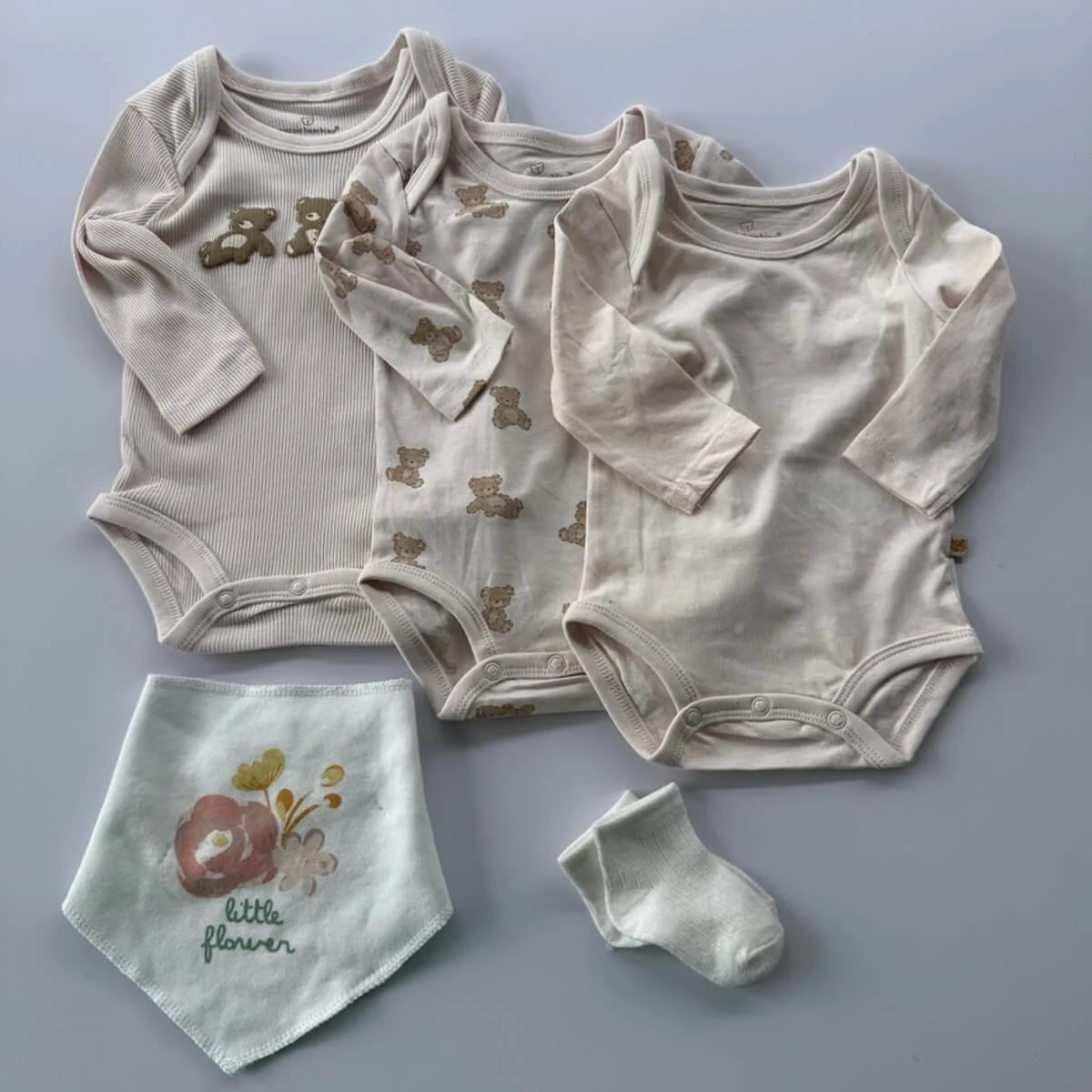 3 body suites in a bear these in pink colours and a bandana bib and a pair of socks.