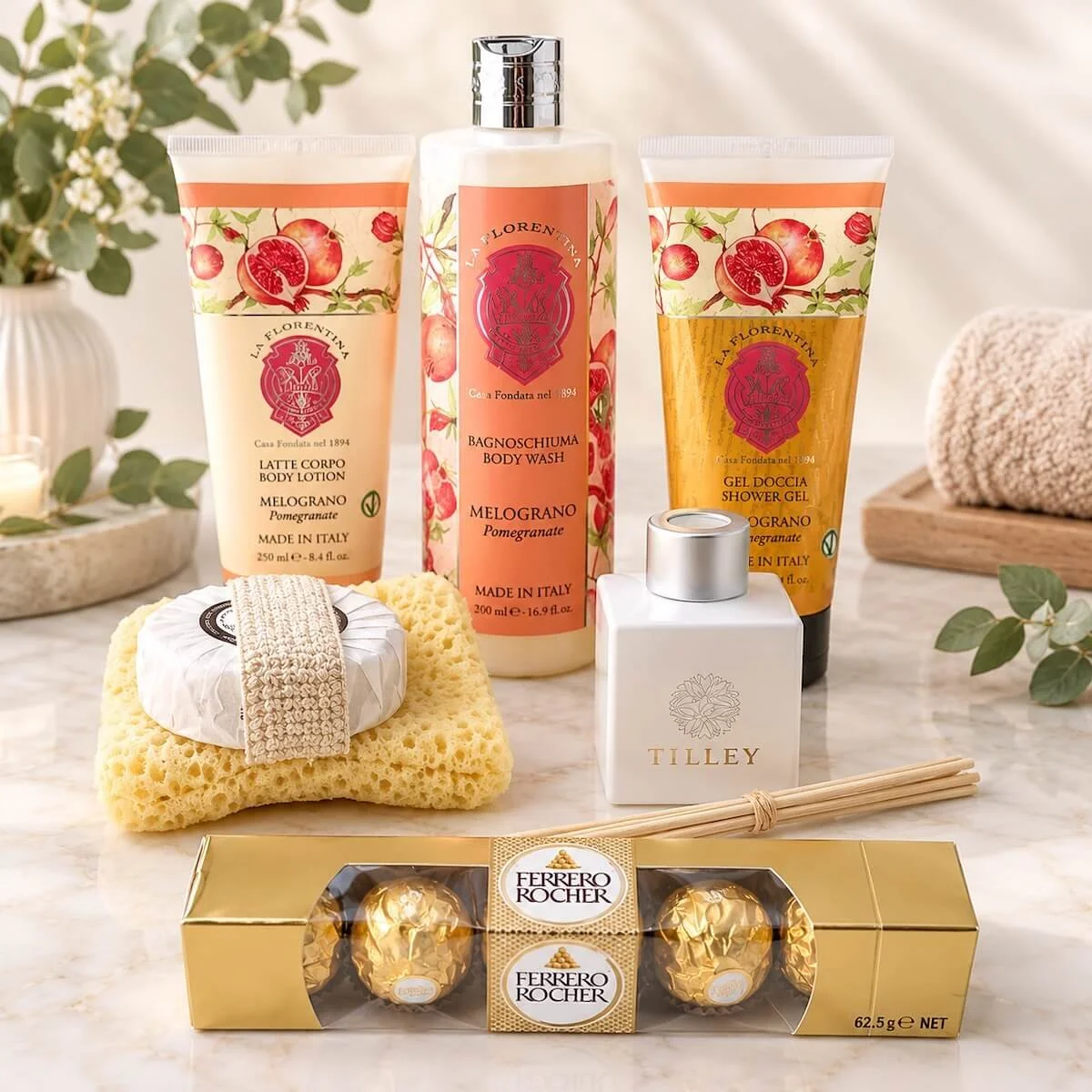 La Florentina pomegranate body wash, lotion and shower gel with Tilley reed diffuser, natural sponge, soap and Ferrero Rocher chocolates, beautifully displayed.
