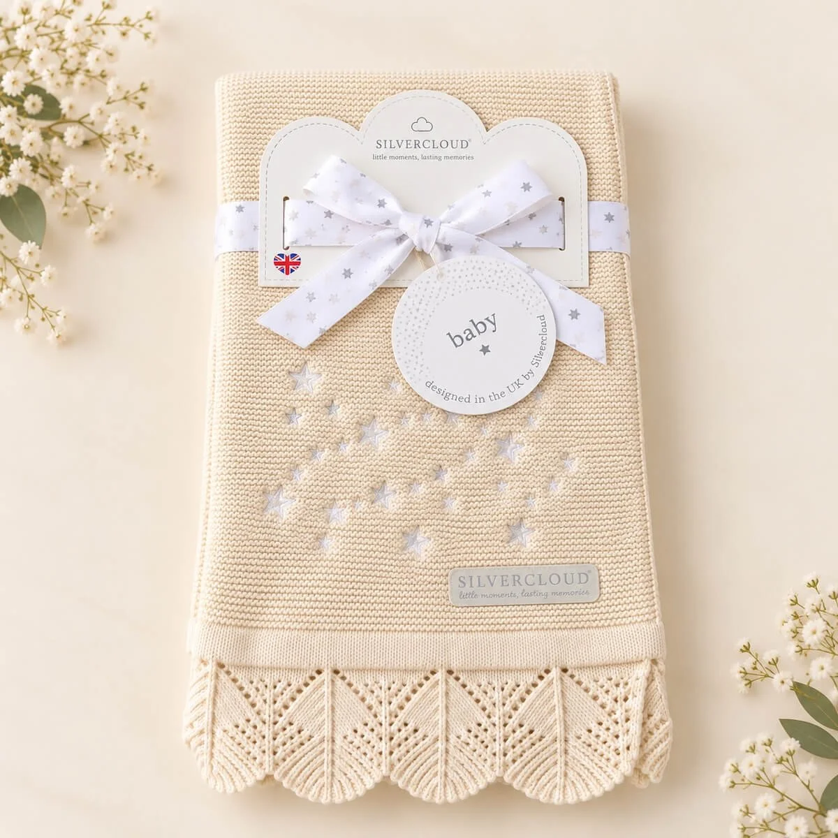 Cream Silvercloud knitted baby blanket with embroidered stars, decorative lace edging and gift ribbon, perfect for a newborn baby gift.