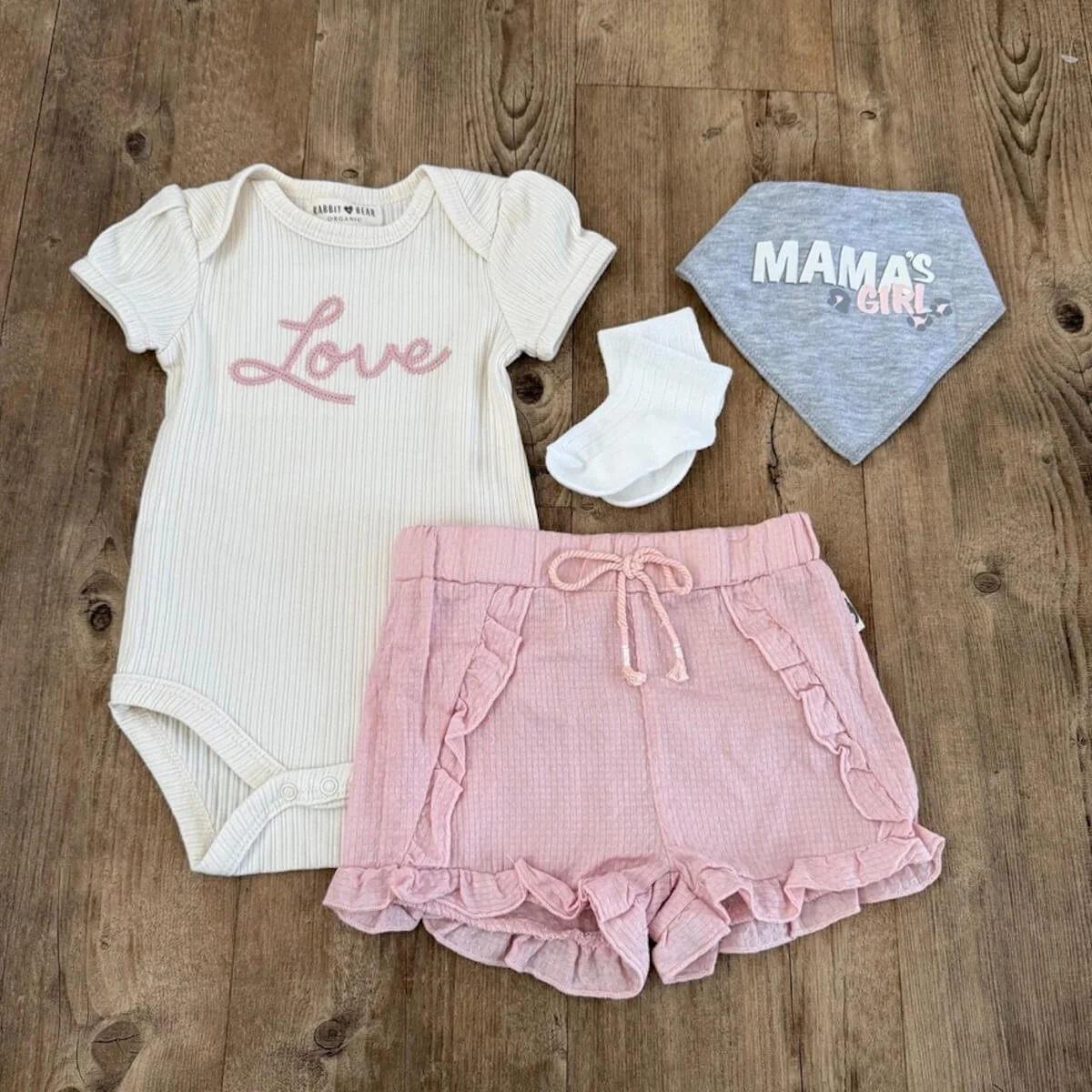 Baby girl clothing set with cream organic onesie embroidered Love, pink shorts, mama’s girl bib and white socks