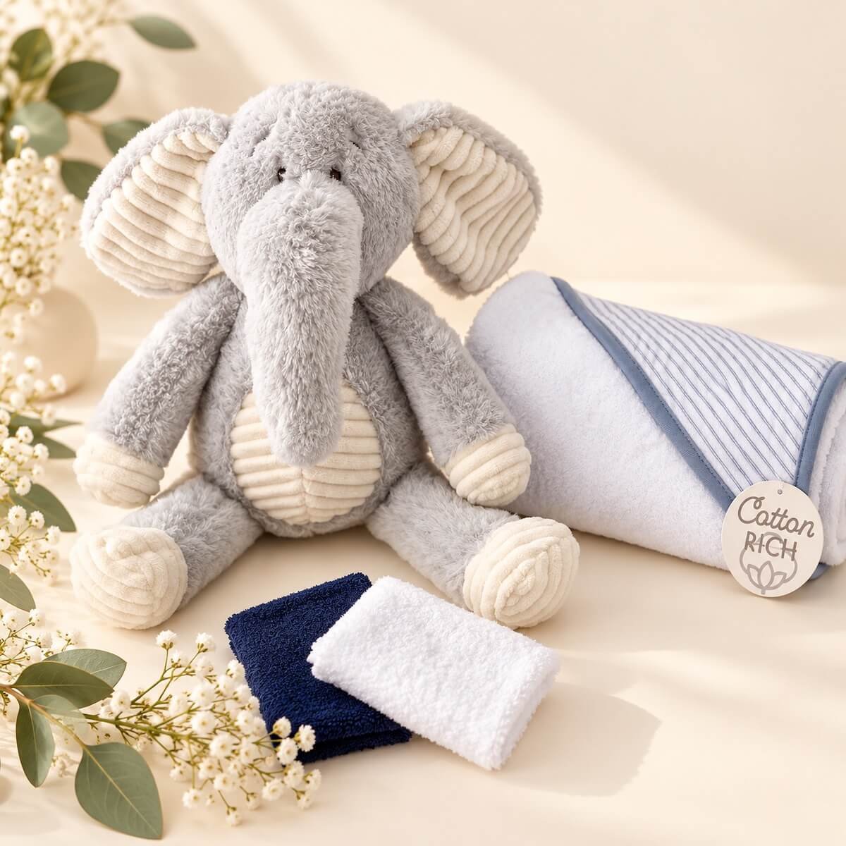 Soft grey plush elephant with cream ears, cotton hooded baby towel and matching washcloths, beautifully displayed for a newborn baby gift.